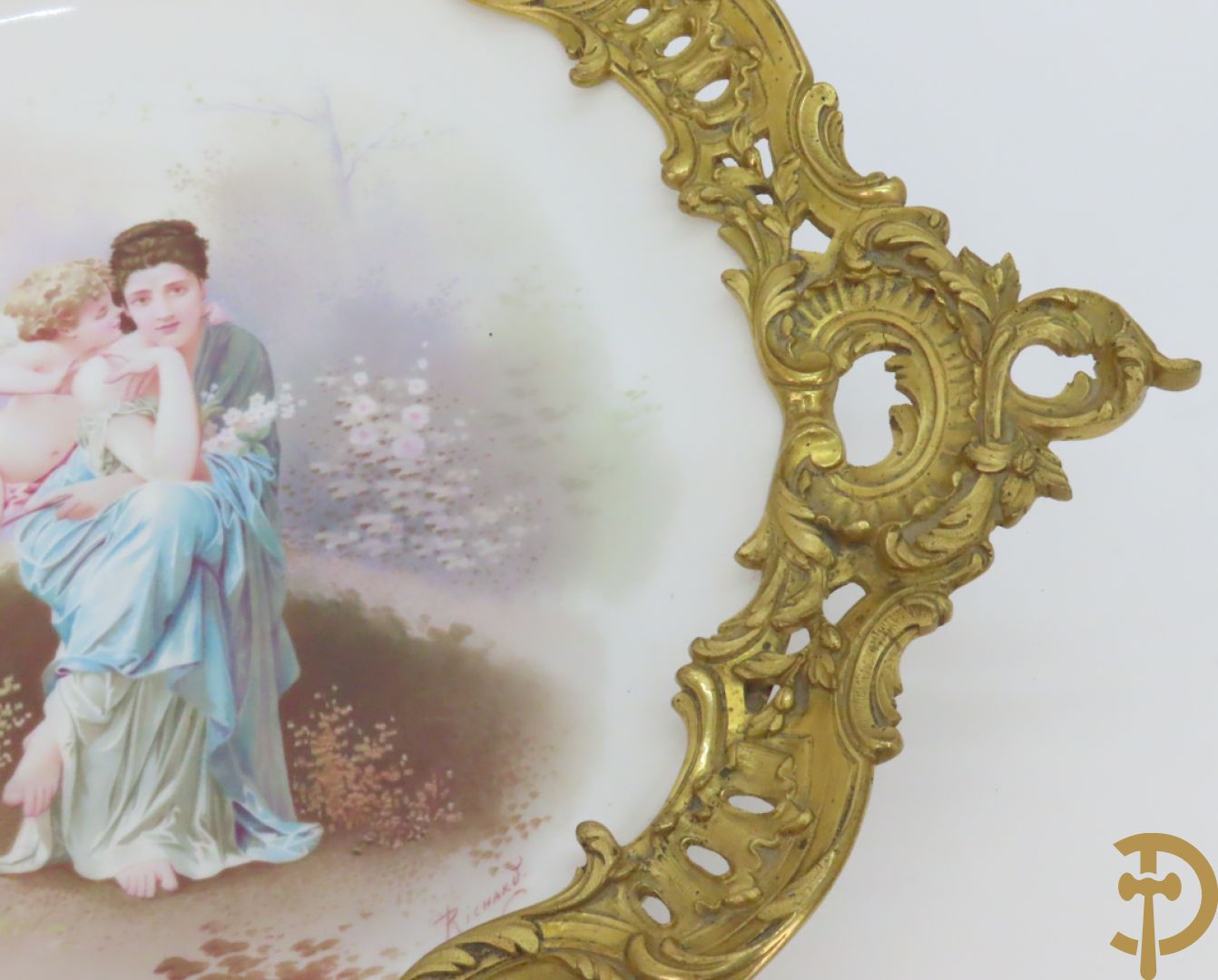 Porseleinen coupe met beschilderd decor van zittende dame met cupido in tuin, Richard getekend, gevat in bronzen houder