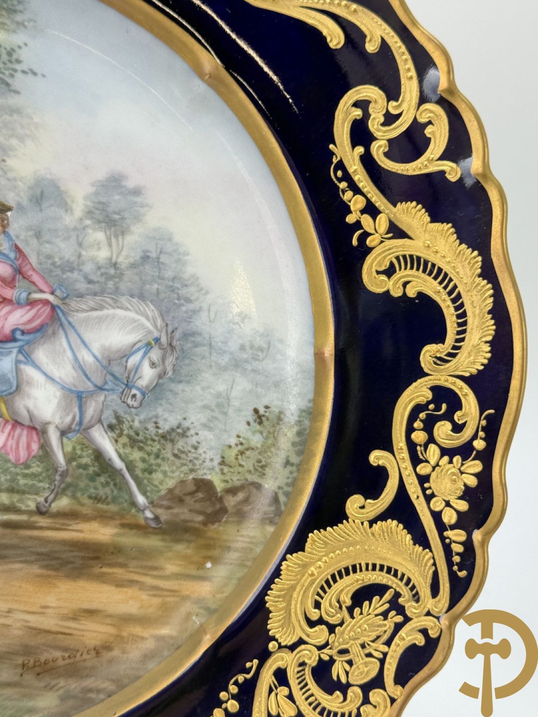 Paar porseleinen borden met ruitertafereel met vergulde omranding, getekend Rivière en Bourdier P., achteraan gemerkt met gekruiste pijlen