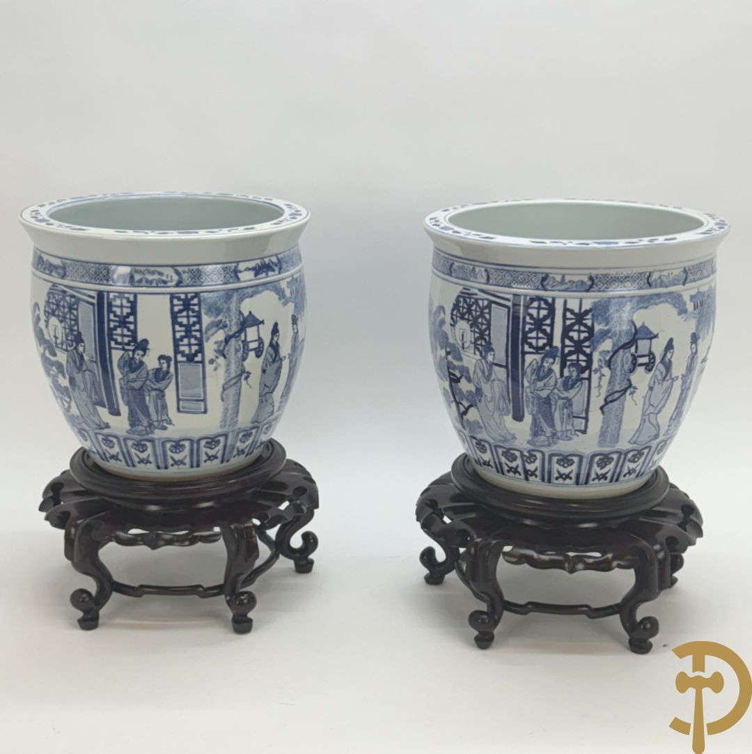 Twee blauw/witte cachepots met geanimeerd landschapsdecor op houten sokkels