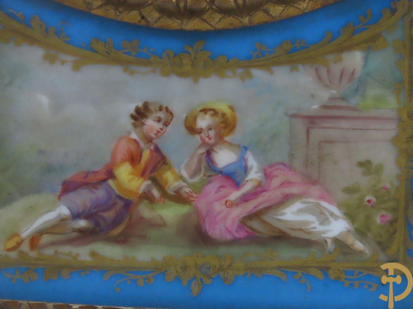 Driedelige bronzen garnituur bezet met Sèvres porselein bestaande uit pendule geflankeerd door paar cupido