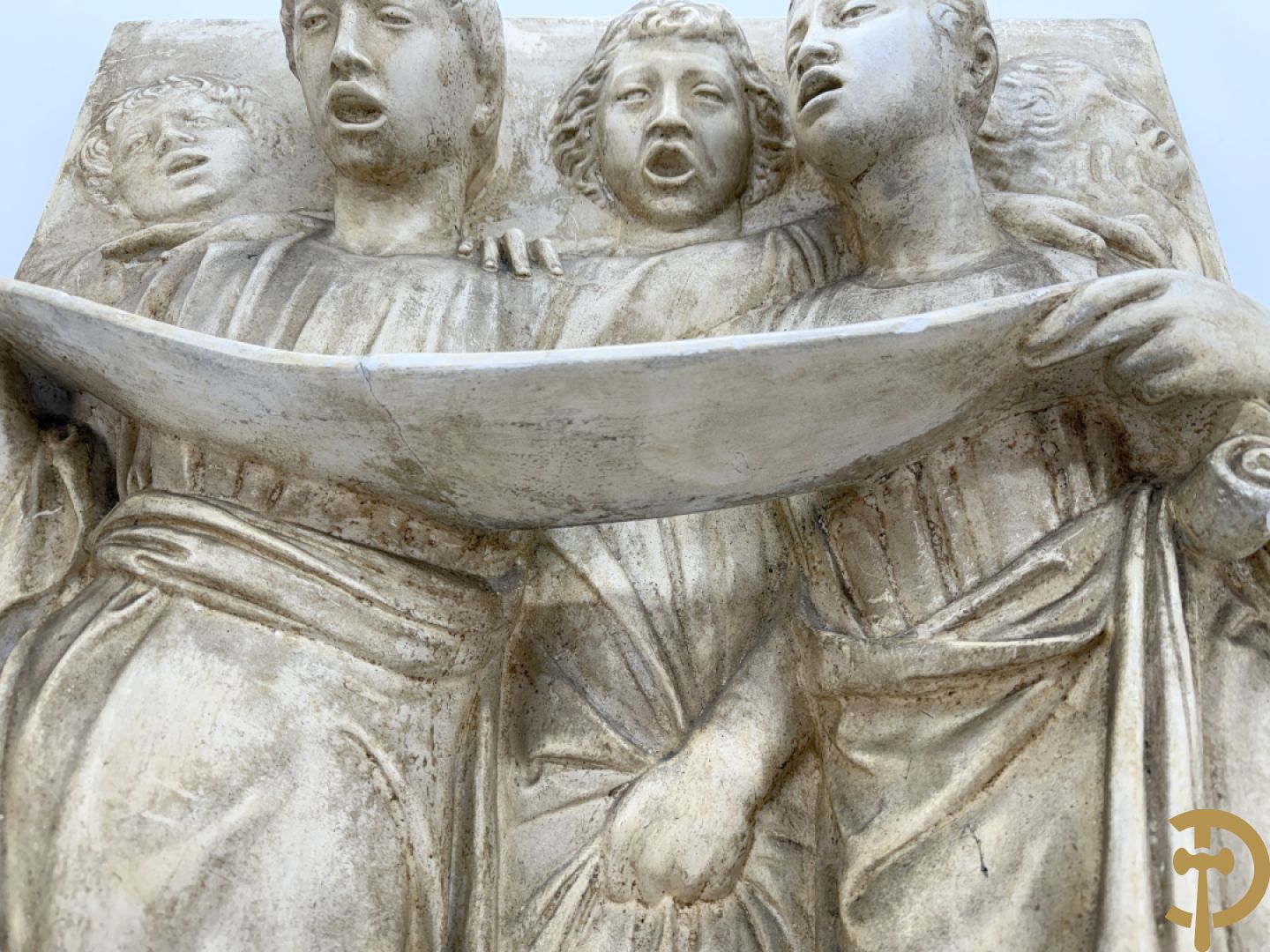 Gipsen basrelief met een zingend jongerenkoor