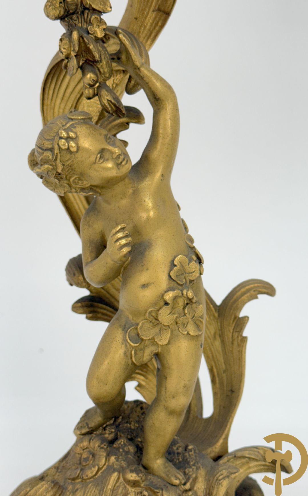 Driedelige vuurvergulde bronzen garnituur, Louis XV stijl, bestaande uit middenstuk met klok omgeven door musicerende cupido