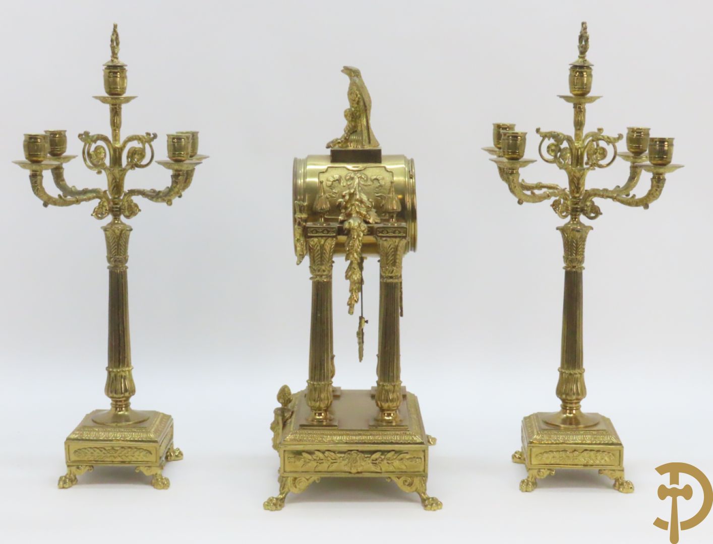 Driedelige bronzen garnituur bestaande uit middenstuk met 4 gecanneleerde zuilen en adelaar bezet + paar kandelaars