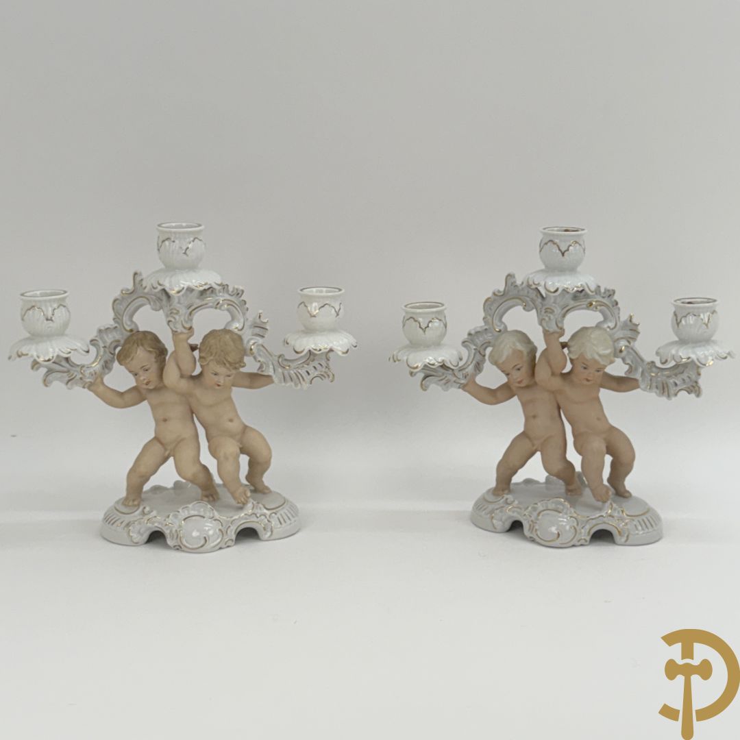 Twee kandelaars in biscuit met cupido