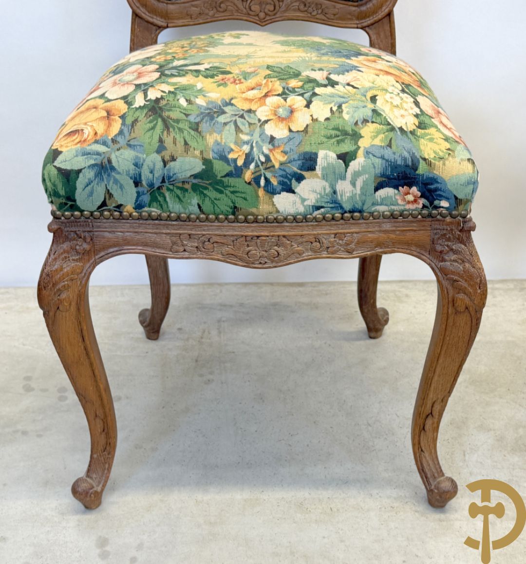 Vier eiken Louis XV stoelen met gebloemde stof en rocailles in de rug, op voluutvormige poten