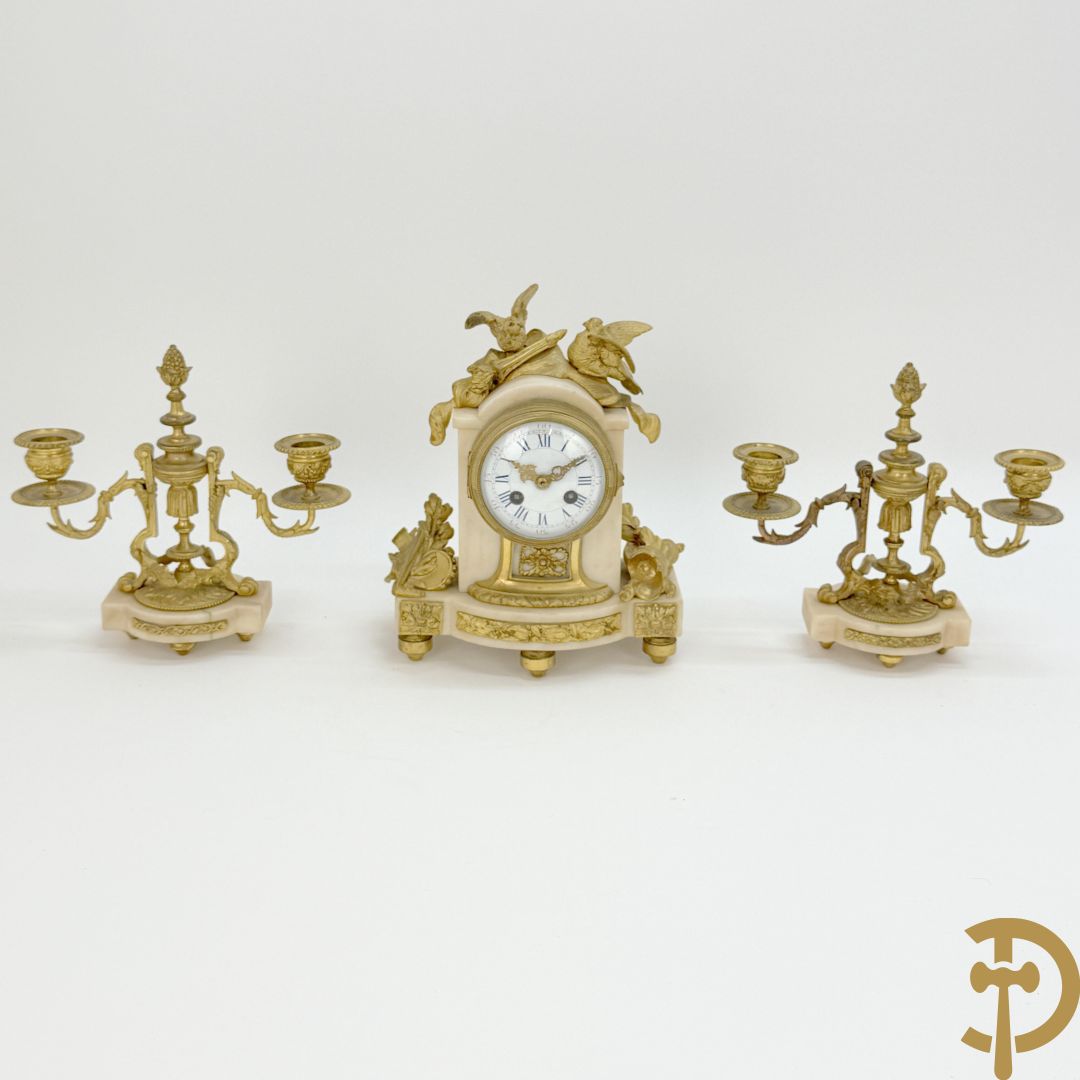 Driedelige garnituur met bronzen ornamenten van vogels en accanthusranken op marmeren basis