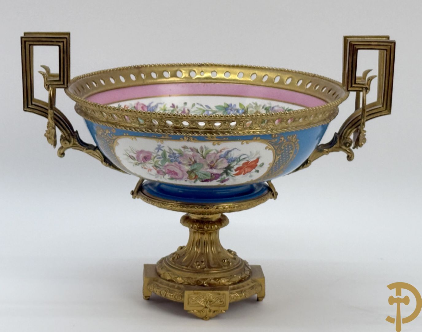 Porseleinen coupe met centraal tafereel en omringd met bloemendecor, gevat in bronzen houder