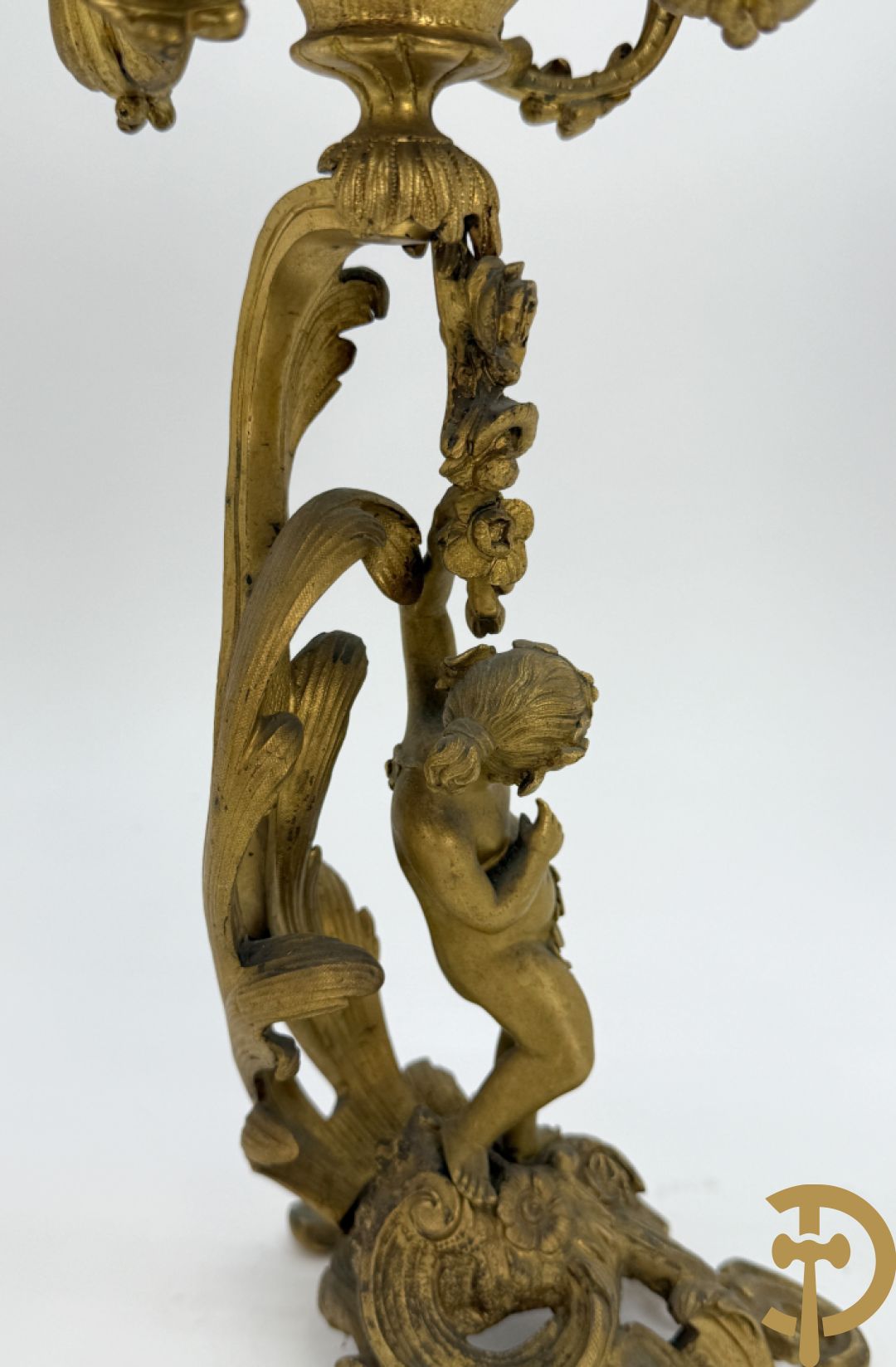 Driedelige vuurvergulde bronzen garnituur, Louis XV stijl, bestaande uit middenstuk met klok omgeven door musicerende cupido