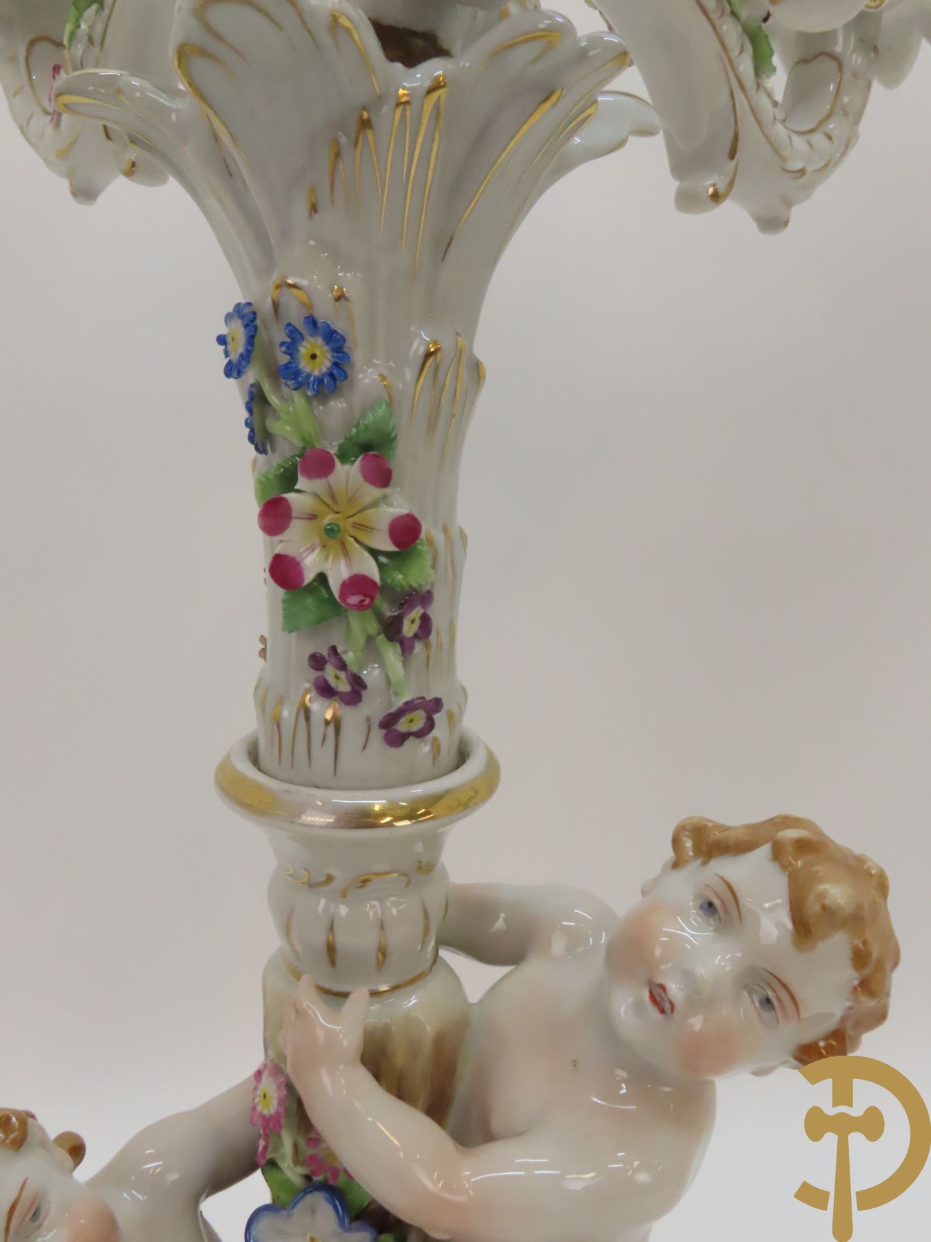 Twee porseleinen vijfarmige kandelaars met cupido