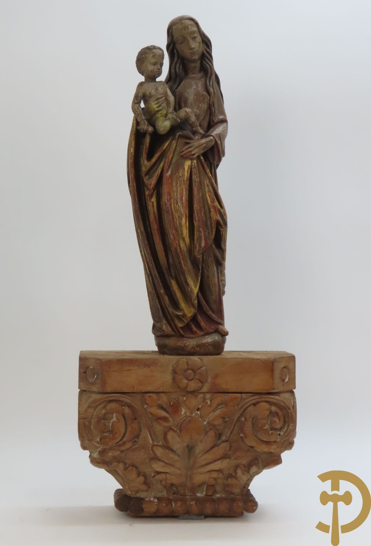 Gepolychromeerde houtsculptuur van madonna met kind gemonteerd op sokkel met accanthusranken