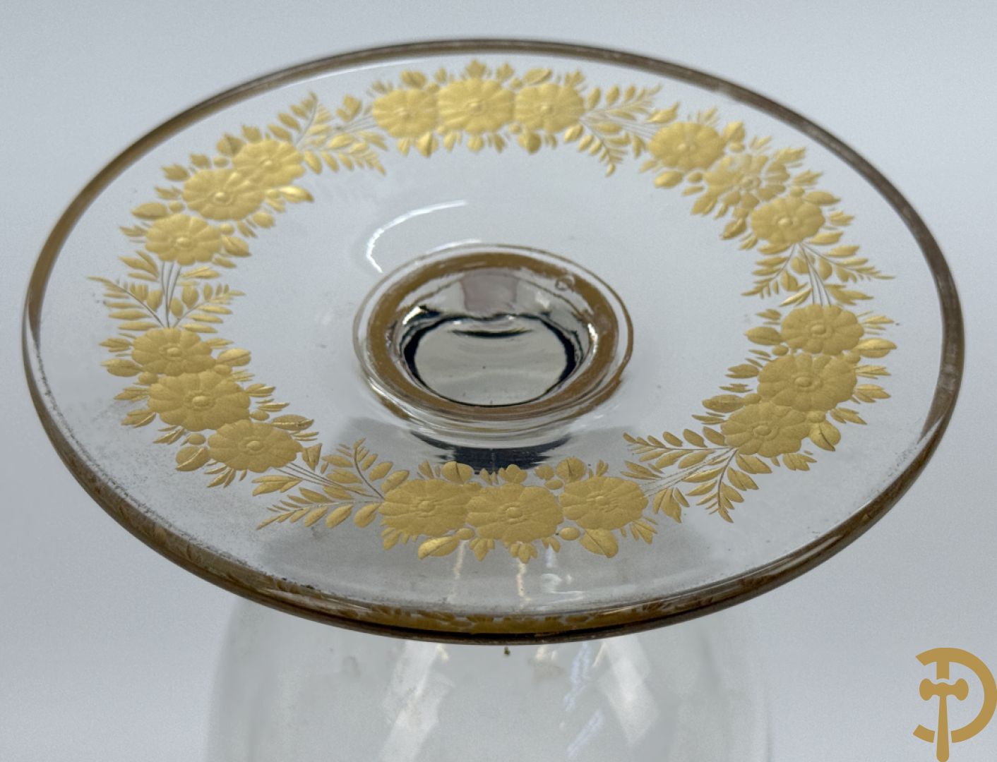 Kristallen vaas met geslepen bloemenmotieven gevuld met goud