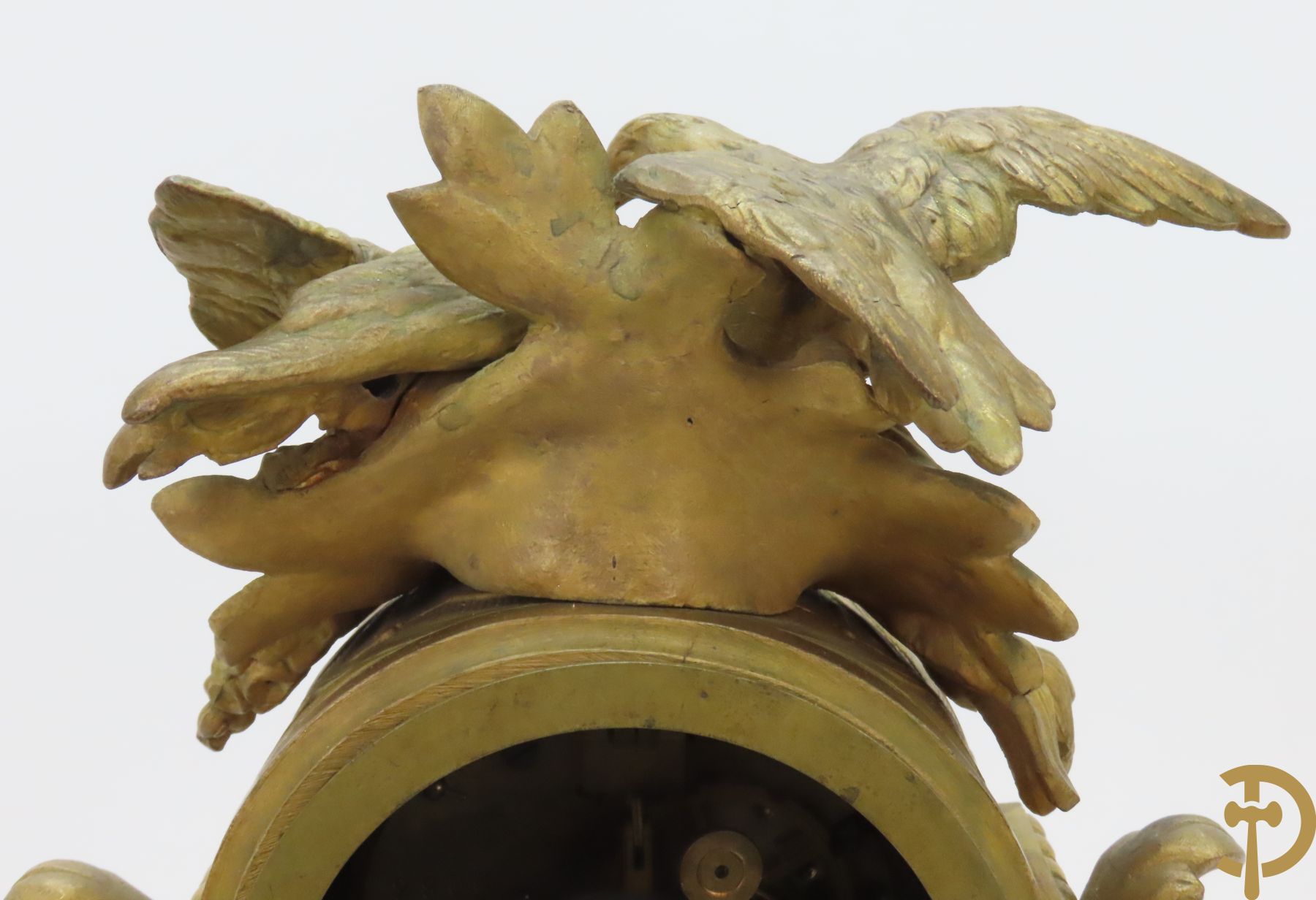 Vergulde pendule in zamak, wijzerplaat bezet met porseleinen plakkettes - bovenaan met vogelpaar, zijdelings met kariathyden houdende een bloementroffee - onder glazen stolp