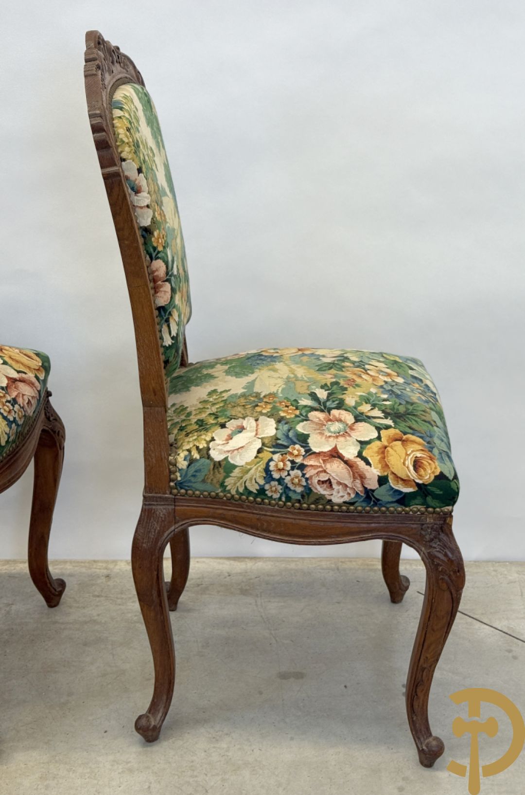 Vier eiken Louis XV stoelen met gebloemde stof en rocailles in de rug, op voluutvormige poten