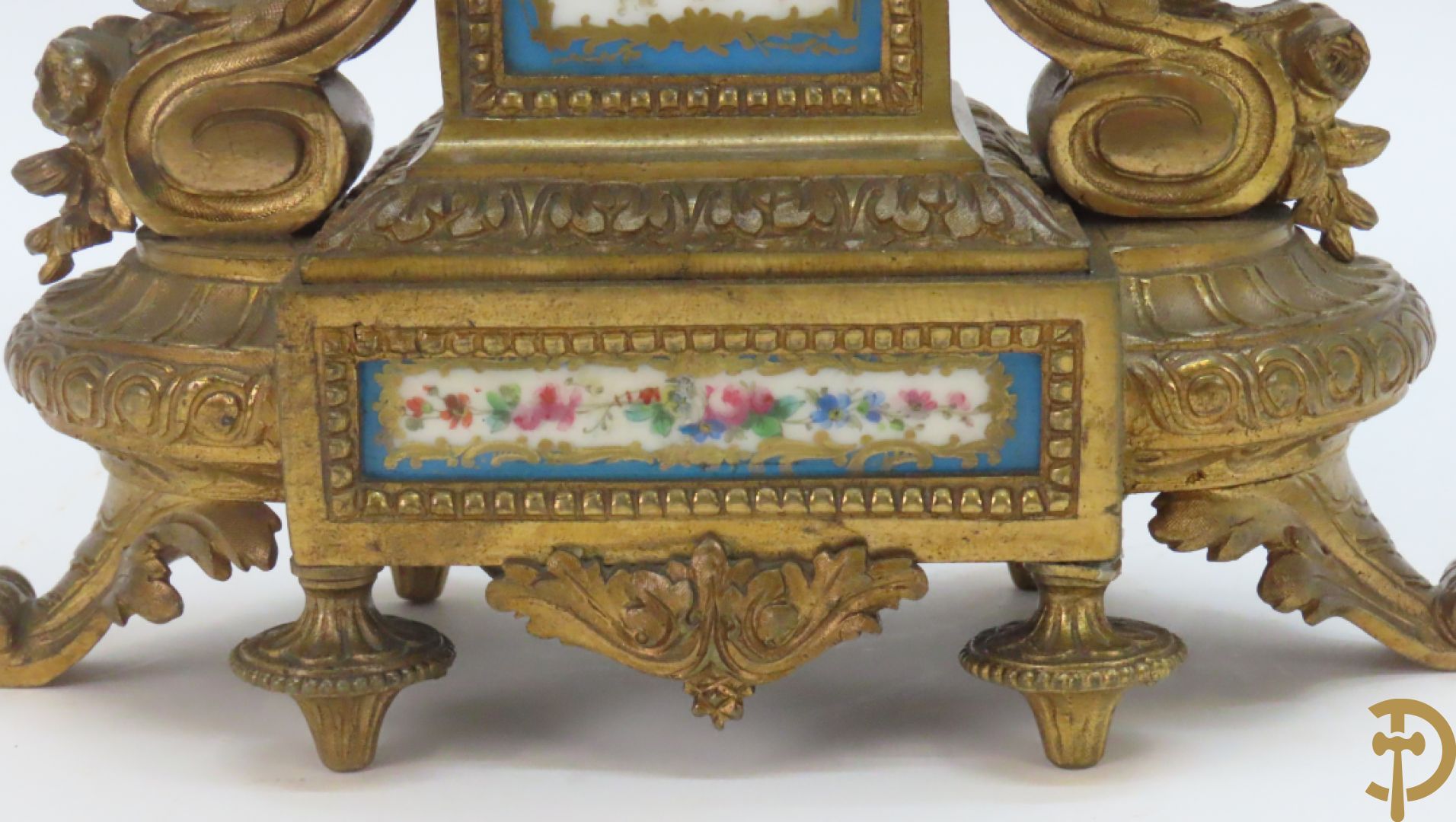 Driedelige bronzen garnituur bezet met Sèvres porselein bestaande uit pendule geflankeerd door paar cupido