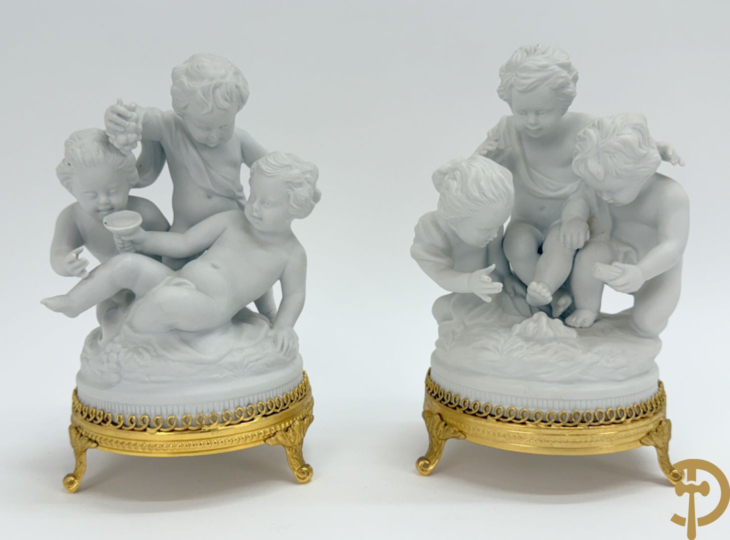 Zeven witte biscuits met voorstelligen van spelende kinderen en engelen op vergulde koperen sokkel, gemerkt Unterweisbach