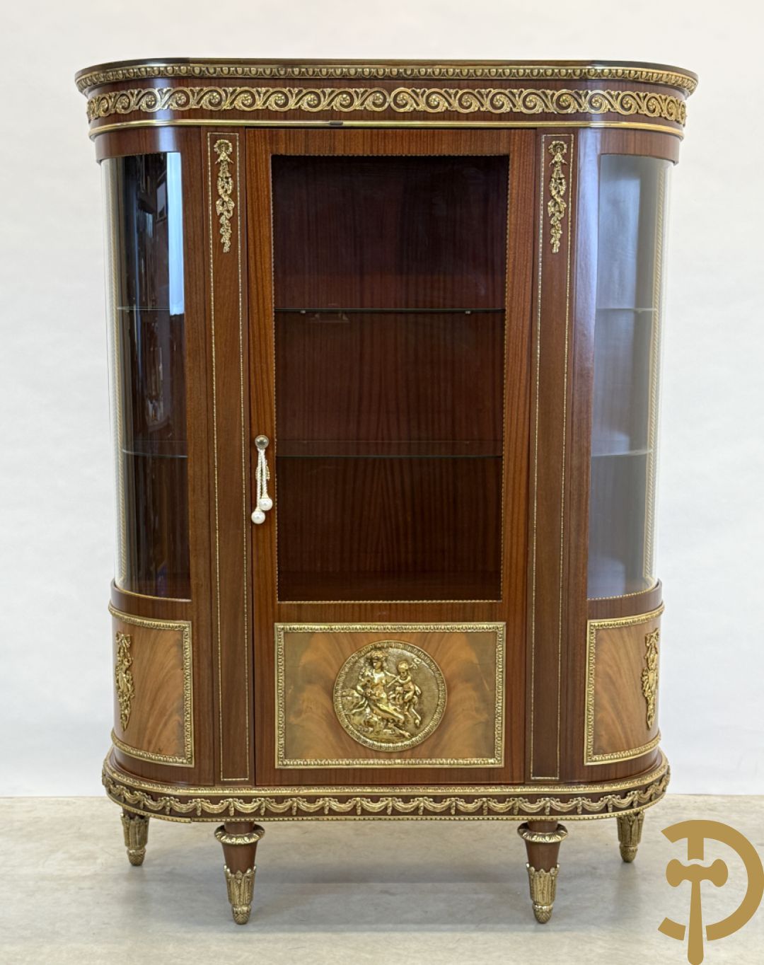 Notelaren vitrine met afgeronde zijkanten, bezet met bronzen plakkettes van dame en cupido