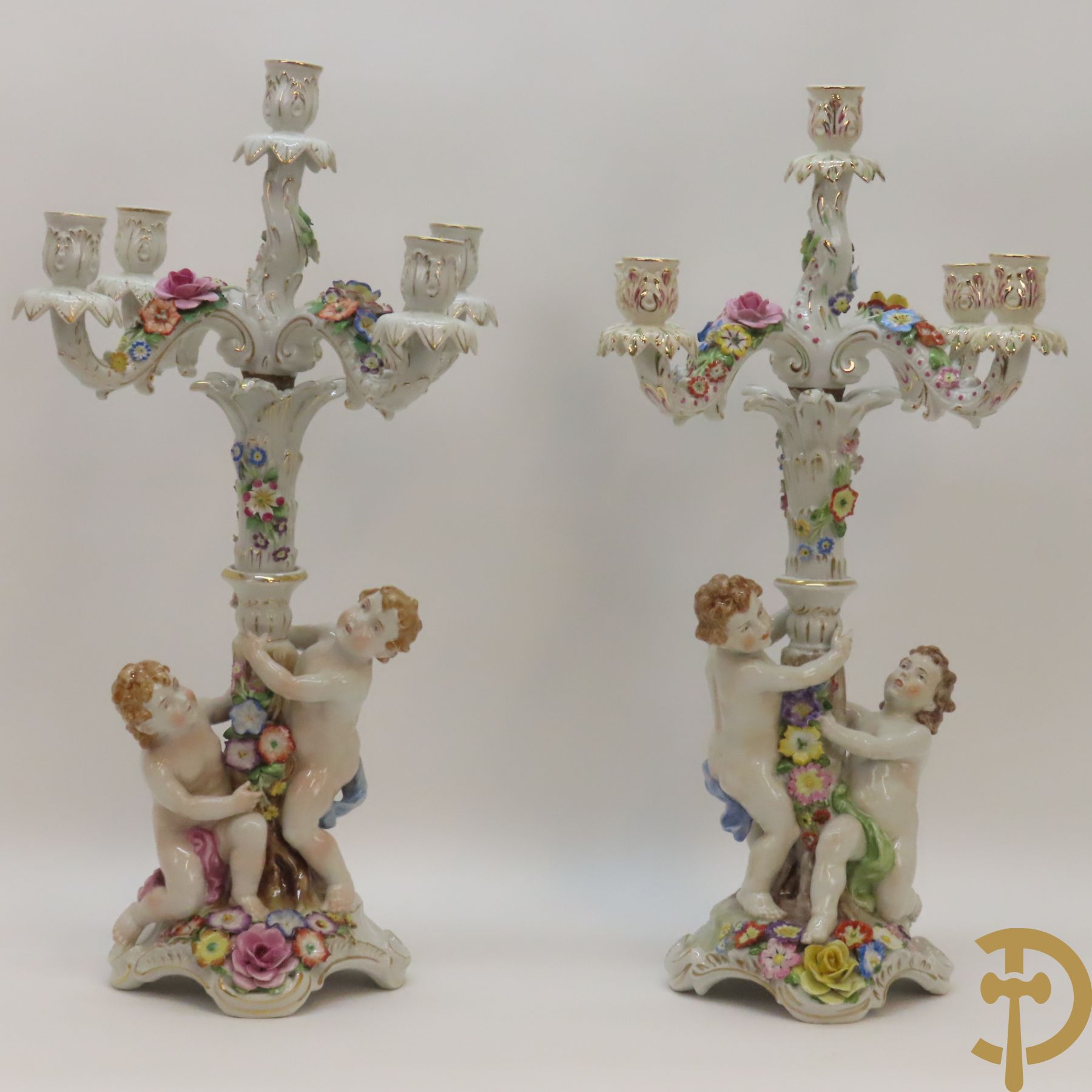 Twee porseleinen vijfarmige kandelaars met cupido