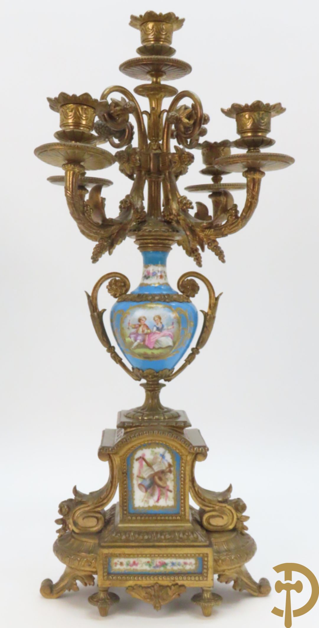 Driedelige bronzen garnituur bezet met Sèvres porselein bestaande uit pendule geflankeerd door paar cupido