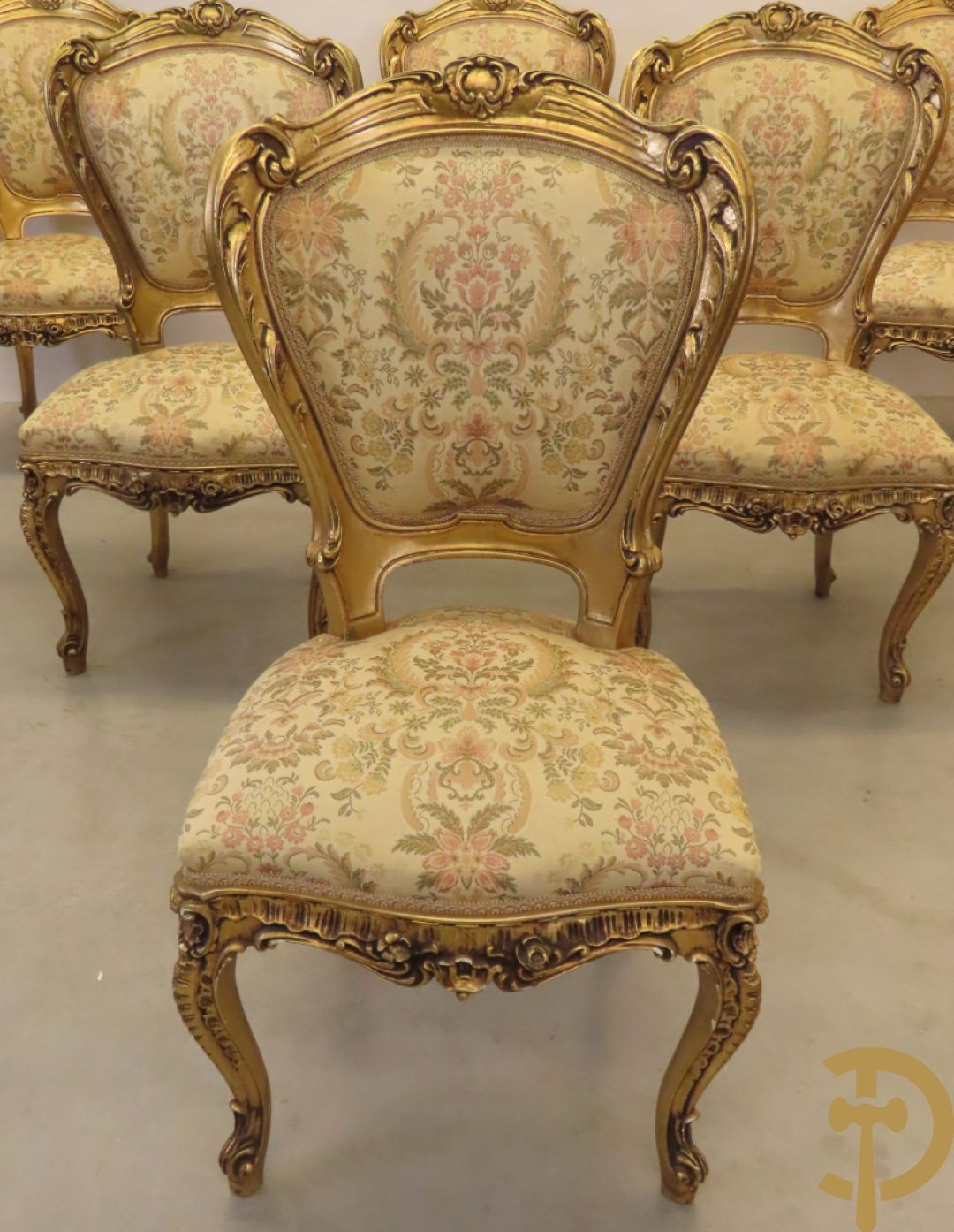 Uitzonderlijke vergulde Louis XV eetkamer bestaande uit vijfdeursdressoir met voluutvormige accanthusranken en rocailles, beschilderd met bloemenmotieven en centraal tafererel met hoornen des overvloeds + bijhorende spiegel vergulde tafel op voluutvormige poten met zes bijhorende stoelen + vitrine met accanthusranken en centrale deur, op voluutvormige poten