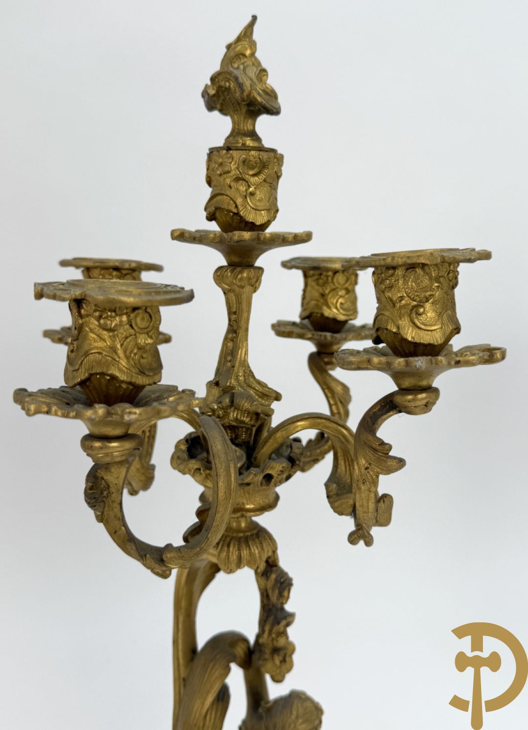 Driedelige vuurvergulde bronzen garnituur, Louis XV stijl, bestaande uit middenstuk met klok omgeven door musicerende cupido