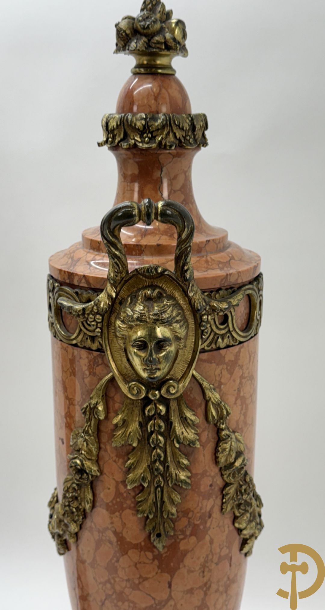 Paar oranje/rode marmeren cassolettes, zijdelings bezet met dameshoofden dragende een guirlande van bloemen - bovenaan met bloementroffee