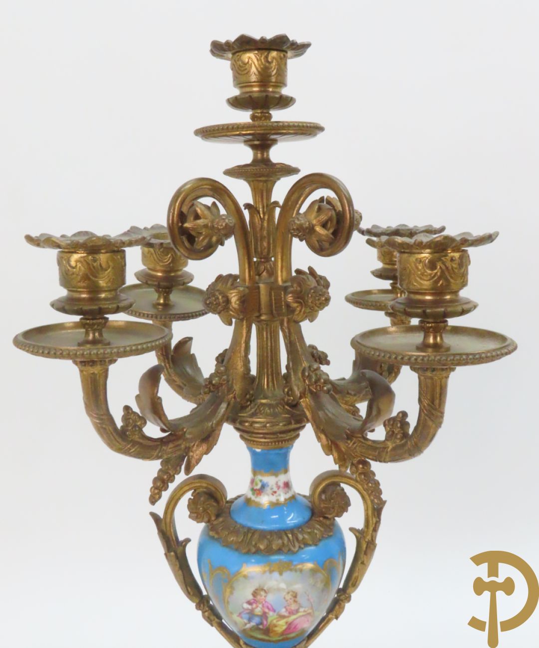 Driedelige bronzen garnituur bezet met Sèvres porselein bestaande uit pendule geflankeerd door paar cupido