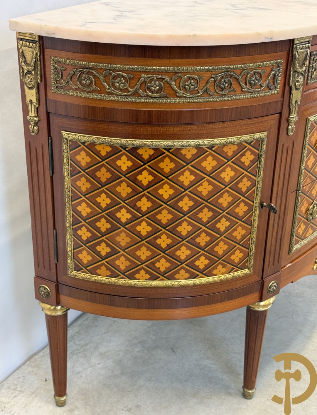 Halve maanvormige drieladencommode met 2 zijdelingse deuren, gemarketteerde bloemenmotieven en bronzen ornamenten, bovenaan bezet met marmeren blad