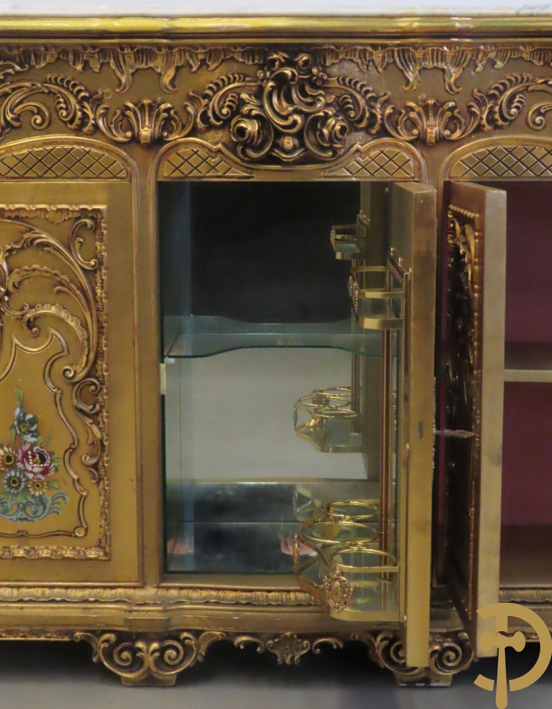 Uitzonderlijke vergulde Louis XV eetkamer bestaande uit vijfdeursdressoir met voluutvormige accanthusranken en rocailles, beschilderd met bloemenmotieven en centraal tafererel met hoornen des overvloeds + bijhorende spiegel vergulde tafel op voluutvormige poten met zes bijhorende stoelen + vitrine met accanthusranken en centrale deur, op voluutvormige poten