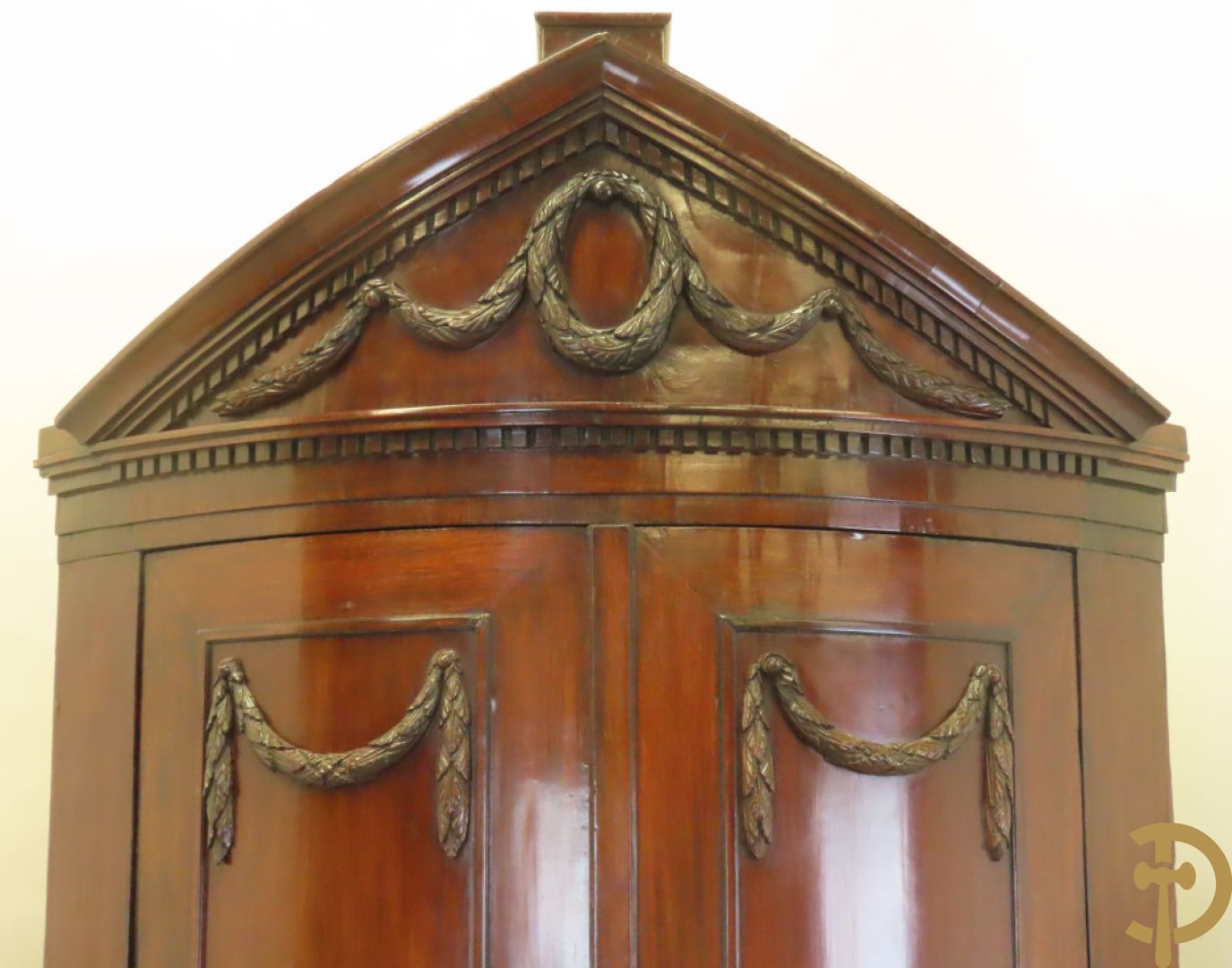 Mahoniehouten hoekkast met gebogen deuren - bovenaan met fronton en Louis XVI motieven, laat 18e