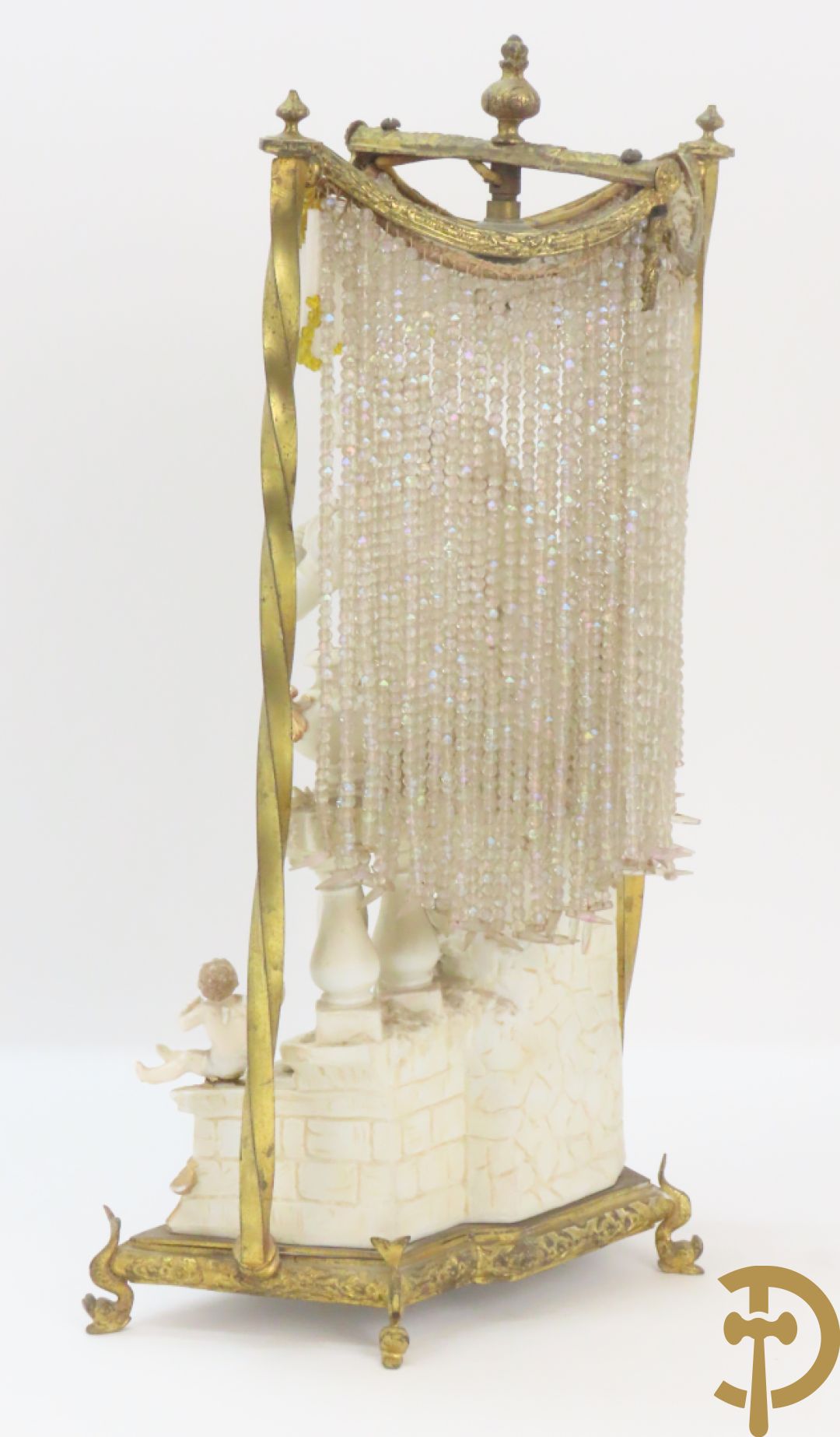 Lieftallig biscuit van romantisch koppel bij amfoor met kleine neergezeten cupido onder koperen baldakijn met kristallen belletjes