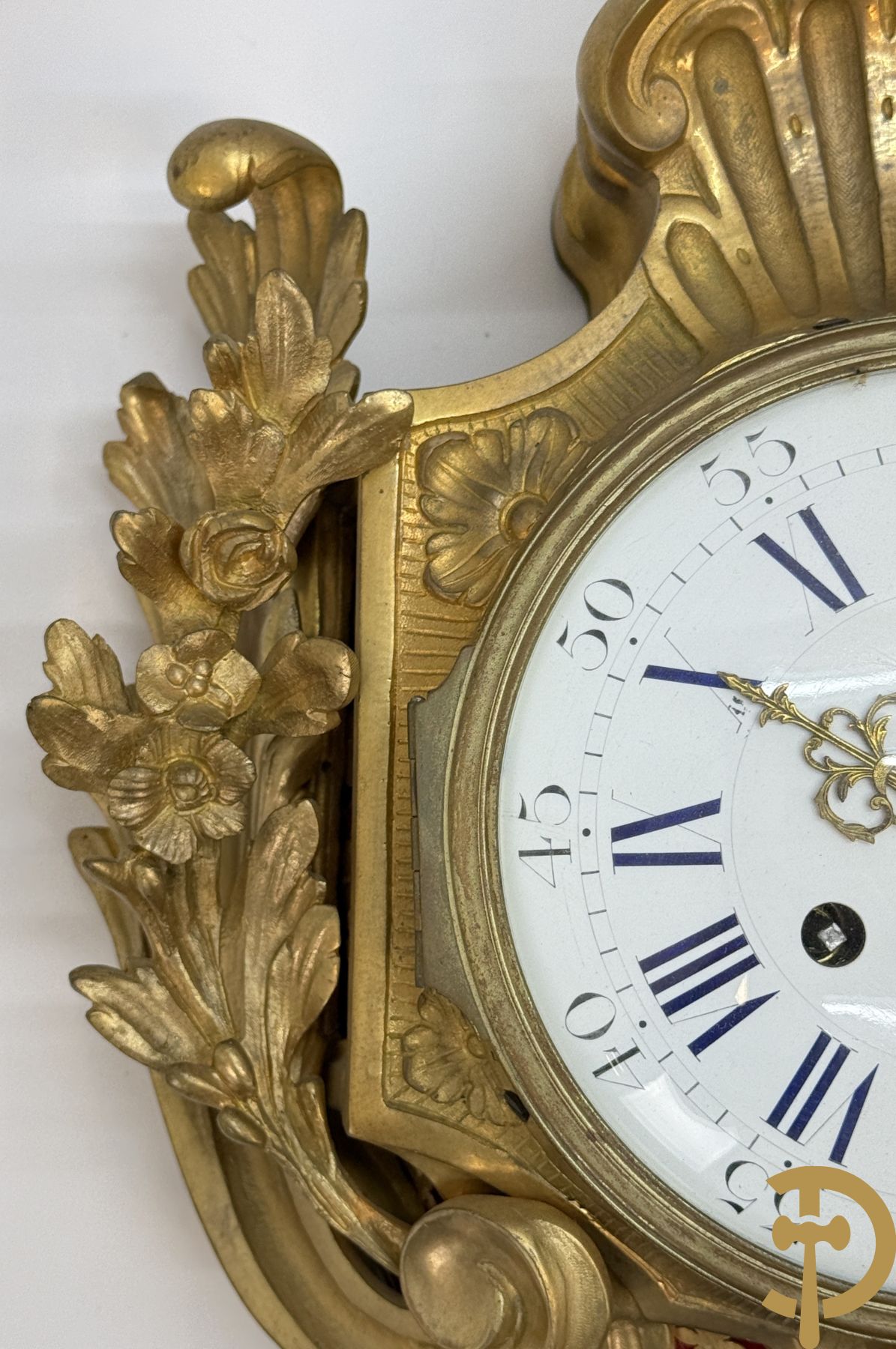 Bronzen muurkartel Louis XV stijl met bloemenmotieven en bovenaan bezet met faune met triangle, Molle Paris getekend binnenin op uurwerk