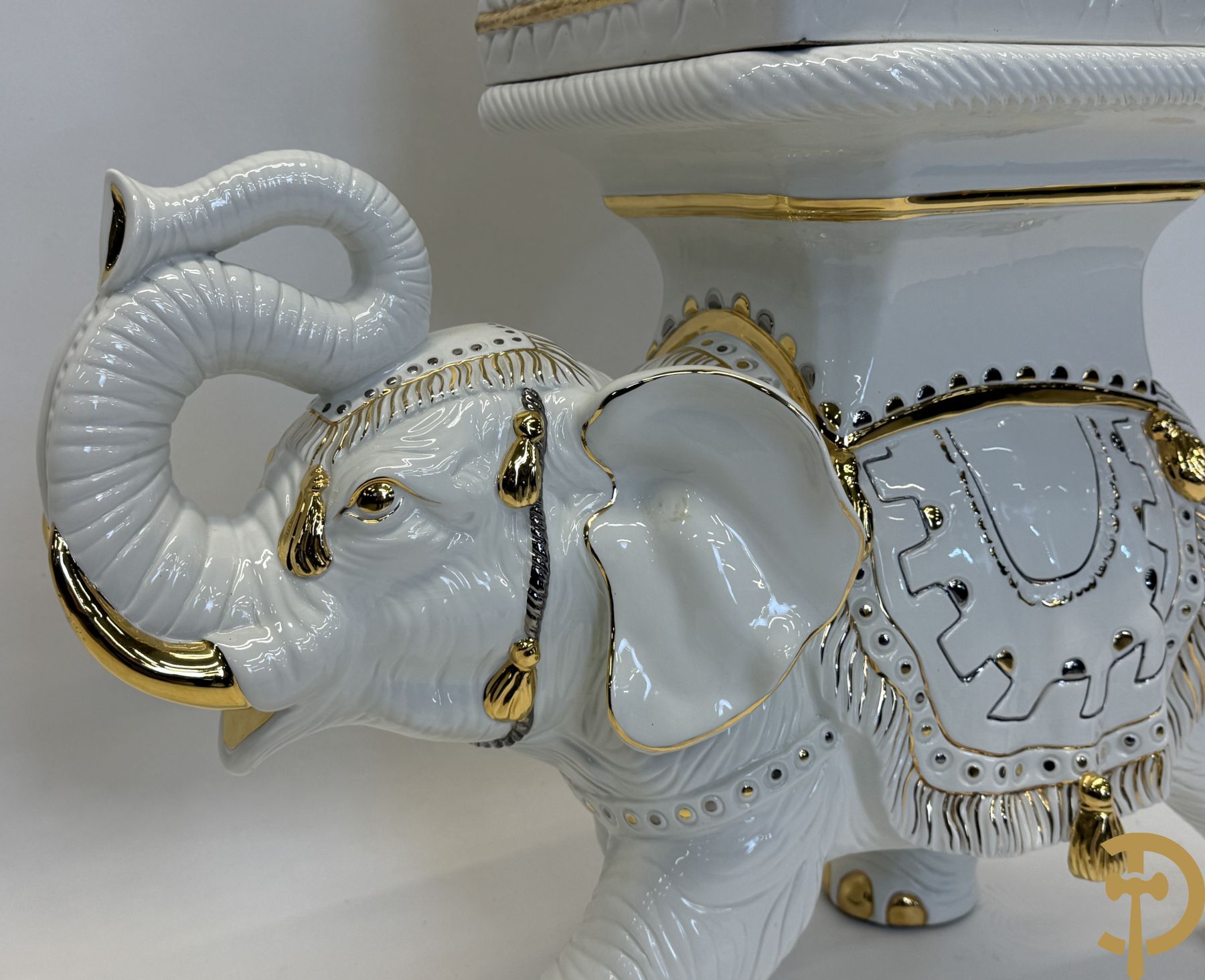 Porseleinen sierbeeld van olifant als staander met daarboven jongeman met bloemencachepot