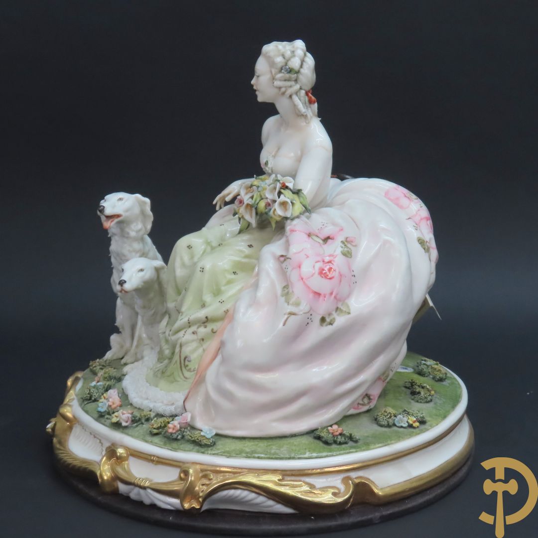 Italiaans porseleinen sierbeeld van zittende dame met 2 windhonden, L. Cazzola getekend en Capo di Monte gemerkt achteraan