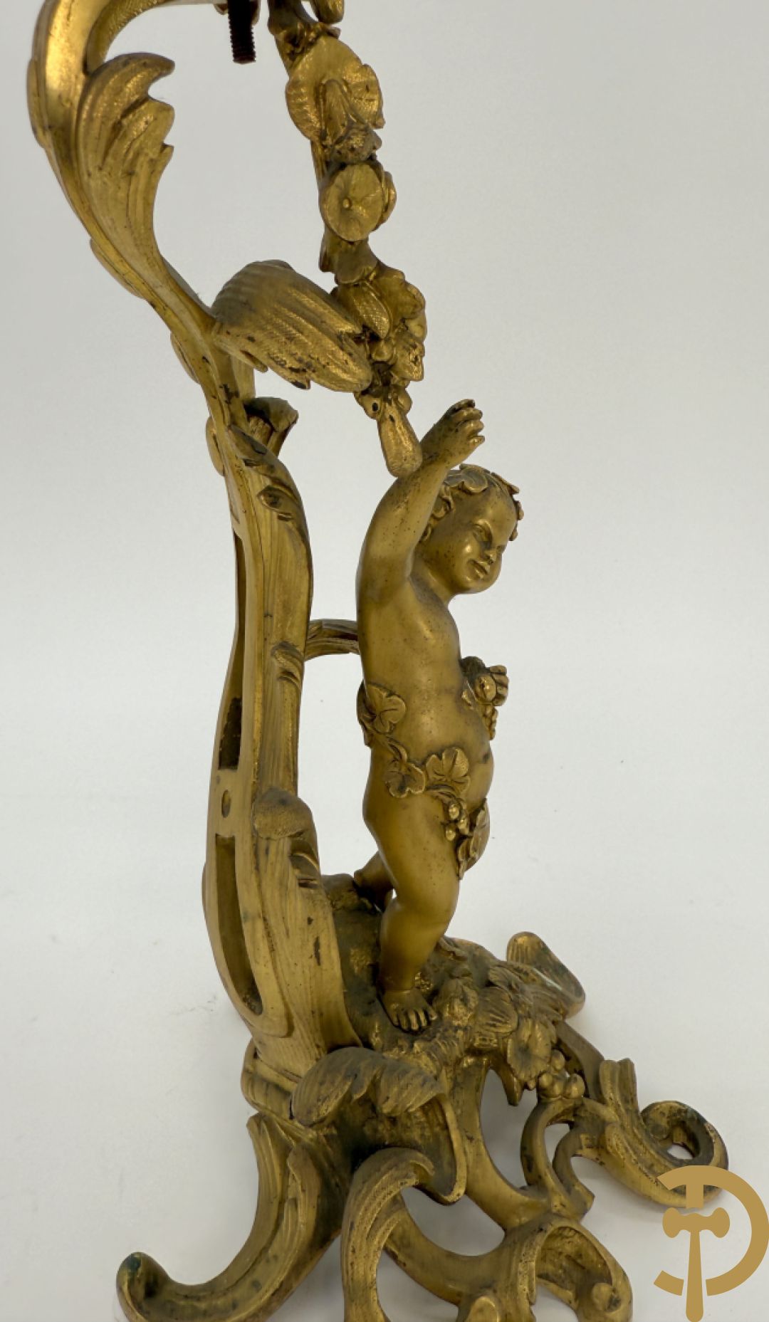 Driedelige vuurvergulde bronzen garnituur, Louis XV stijl, bestaande uit middenstuk met klok omgeven door musicerende cupido