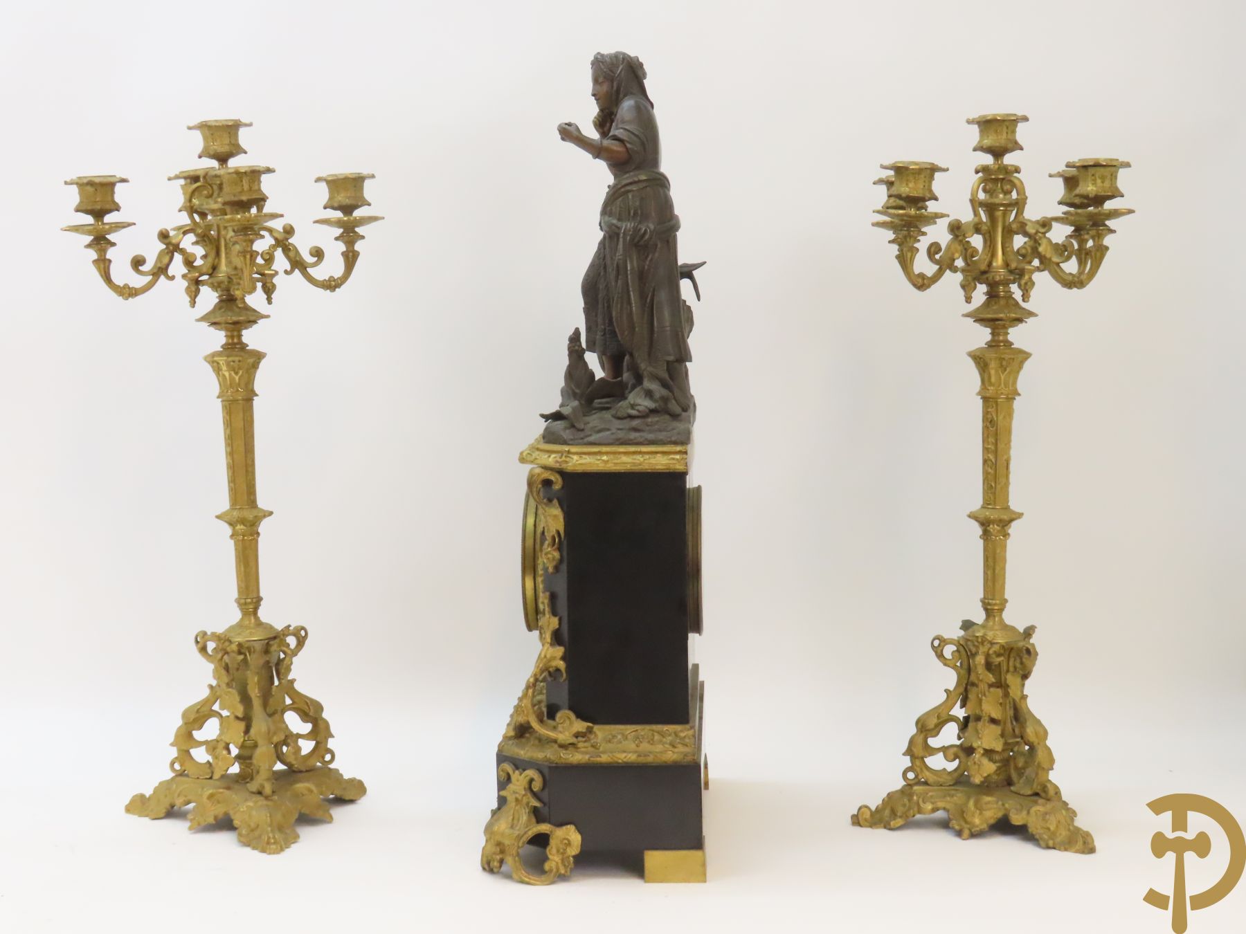 Napoleon III pendule met zwarte marmer, bovenaan bekroond met dame met amfoor en geflankeerd door paar bronzen kandelaars