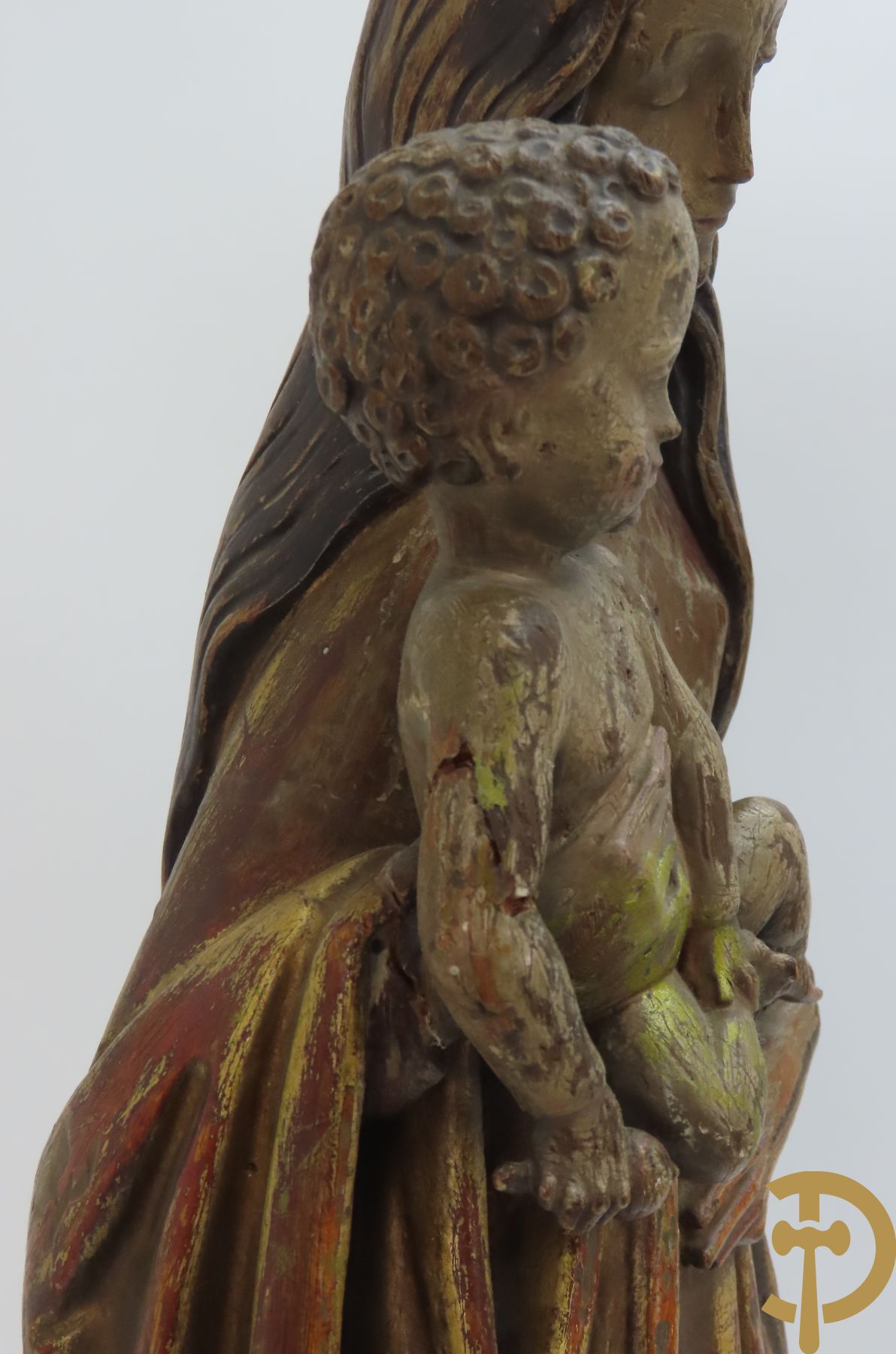 Gepolychromeerde houtsculptuur van madonna met kind gemonteerd op sokkel met accanthusranken