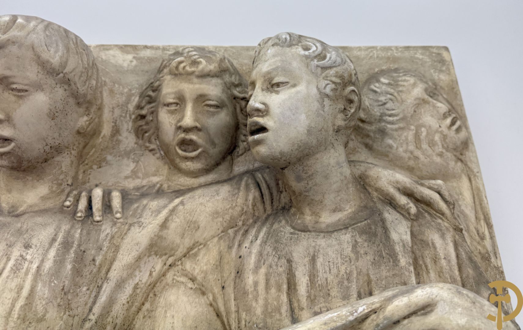 Gipsen basrelief met een zingend jongerenkoor