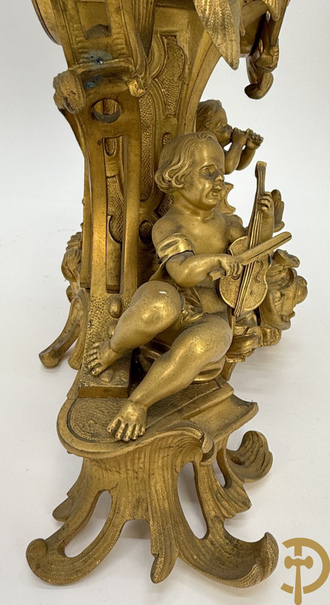 Driedelige vuurvergulde bronzen garnituur, Louis XV stijl, bestaande uit middenstuk met klok omgeven door musicerende cupido