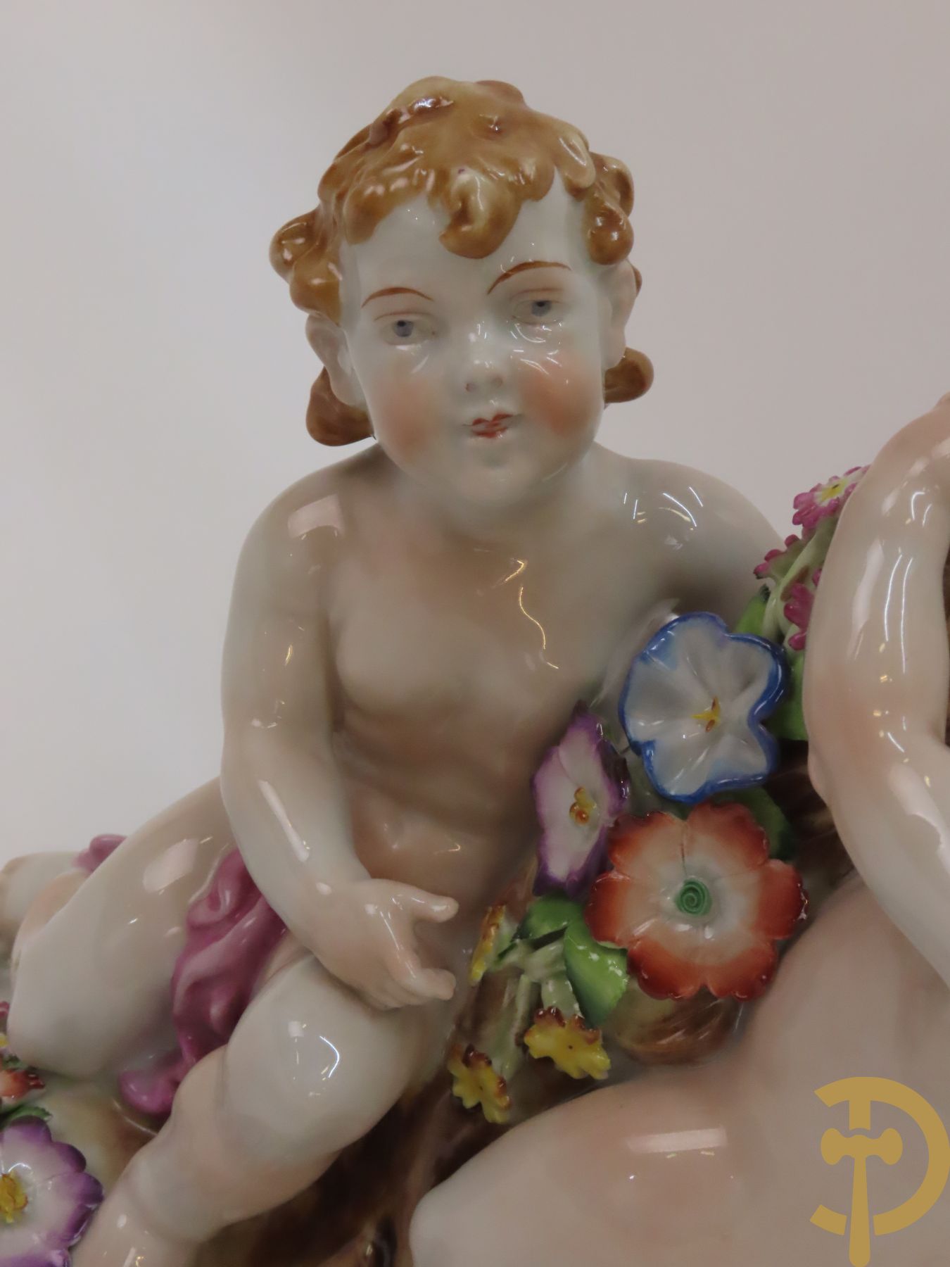 Twee porseleinen vijfarmige kandelaars met cupido