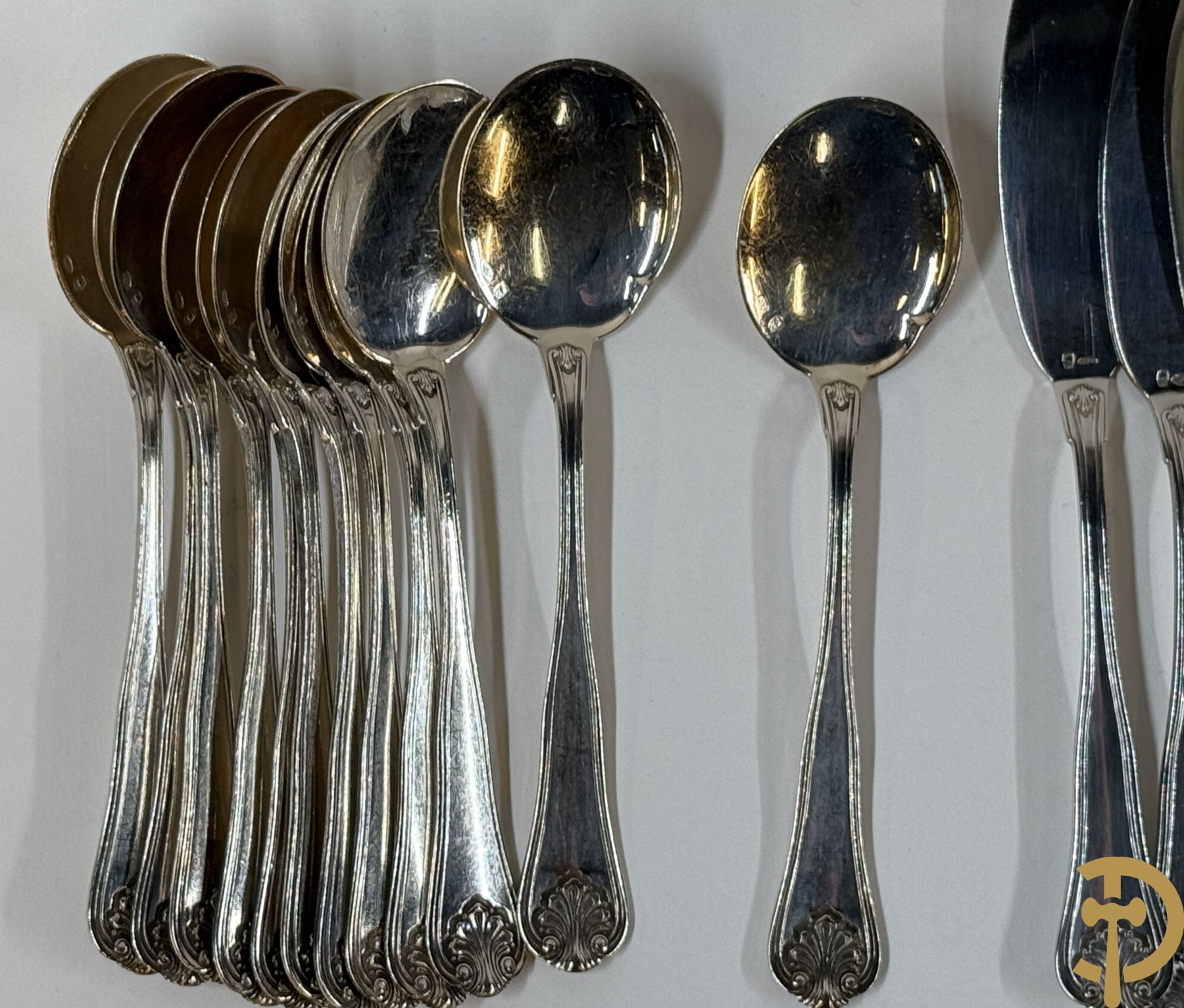 Massief zilveren bestek Wolfers bestaande uit 12 vorken (979 gram), 12 lepels (1028 gram), 11 messen, 12 visvorken (553 gram), 12 vismessen (690 gram), 12 dessertmessen, 10 koffielepels (296 gram), 12 ijslepels (369 gram), 3 botermesjes en scheplepeltje (165 gram), 5  grote stukken (samen 557 gram) waarvan slacouvert, 2 taartscheppen en wildvork + sauslepel met zelfde decor maar Metal Blanc