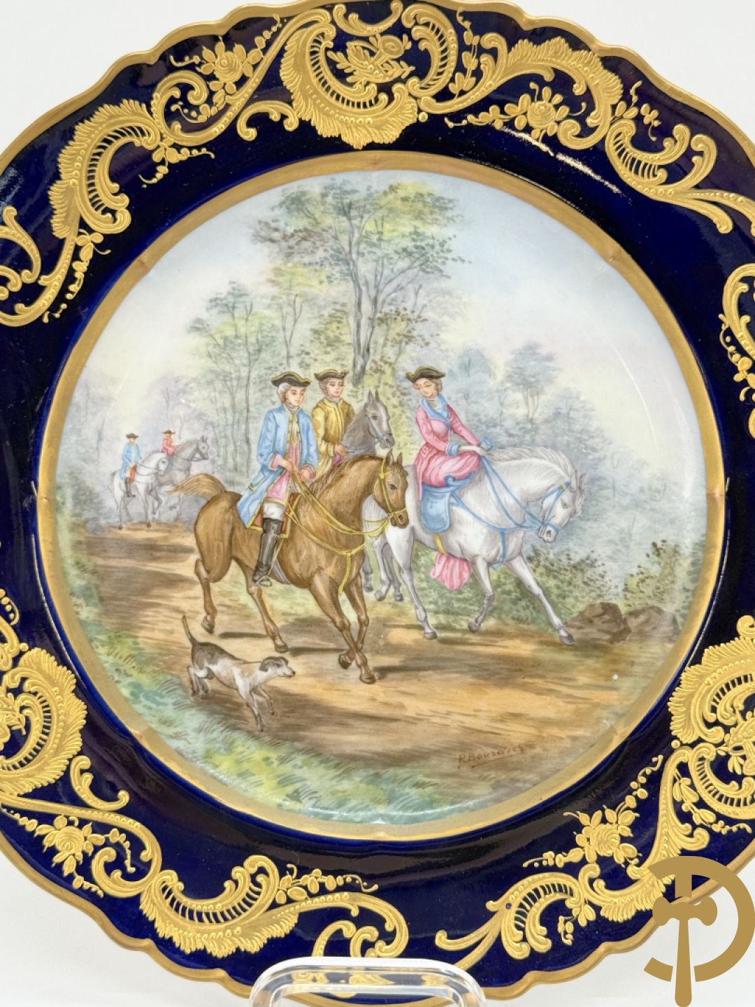 Paar porseleinen borden met ruitertafereel met vergulde omranding, getekend Rivière en Bourdier P., achteraan gemerkt met gekruiste pijlen