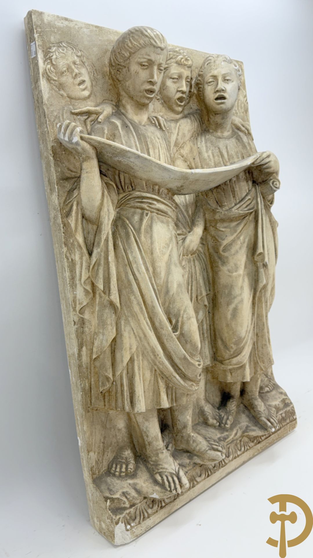 Gipsen basrelief met een zingend jongerenkoor