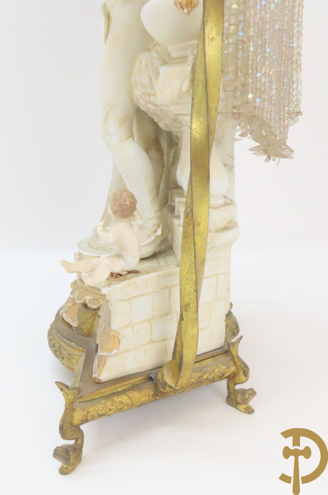 Lieftallig biscuit van romantisch koppel bij amfoor met kleine neergezeten cupido onder koperen baldakijn met kristallen belletjes