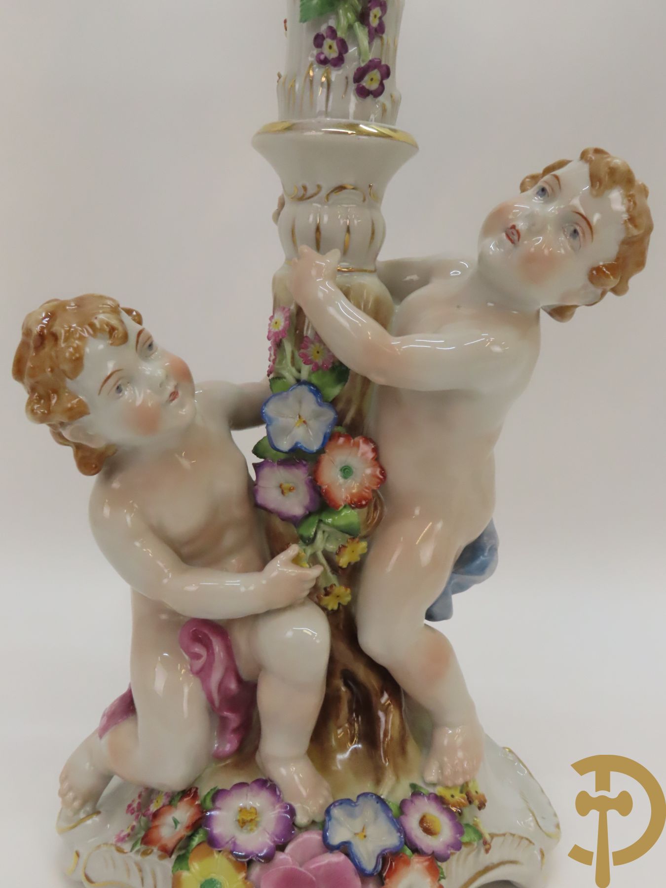 Twee porseleinen vijfarmige kandelaars met cupido
