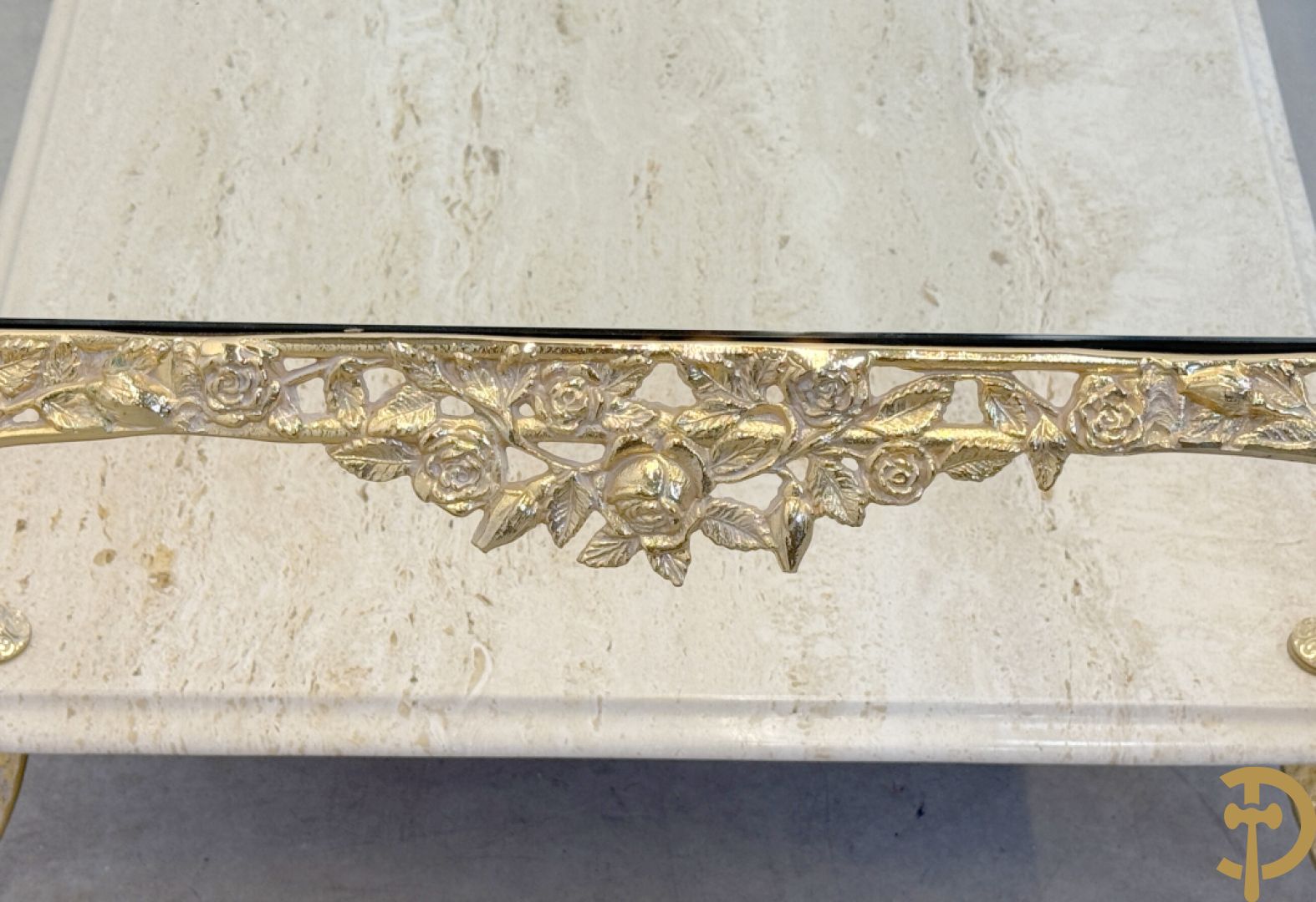 Salontafel met glazen blad op gebogen voluutvormige koperen poten gemaakt van bladranken - onderaan met travertin blad