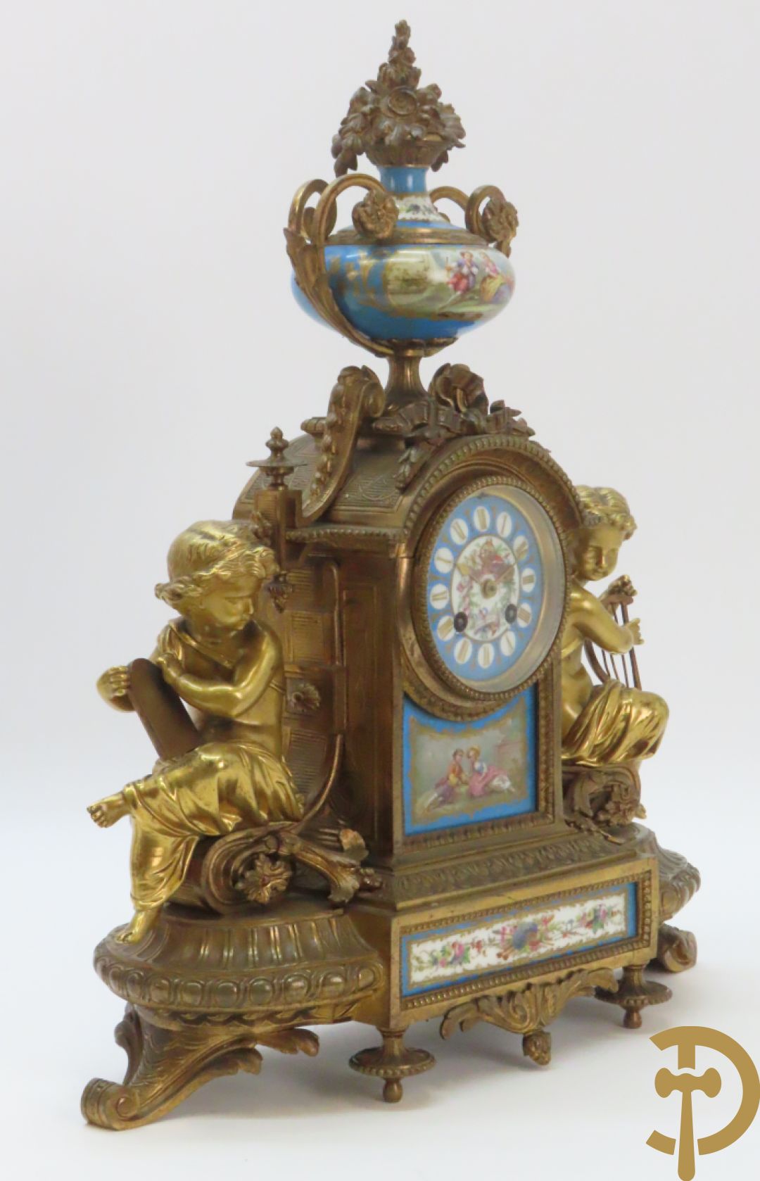 Driedelige bronzen garnituur bezet met Sèvres porselein bestaande uit pendule geflankeerd door paar cupido