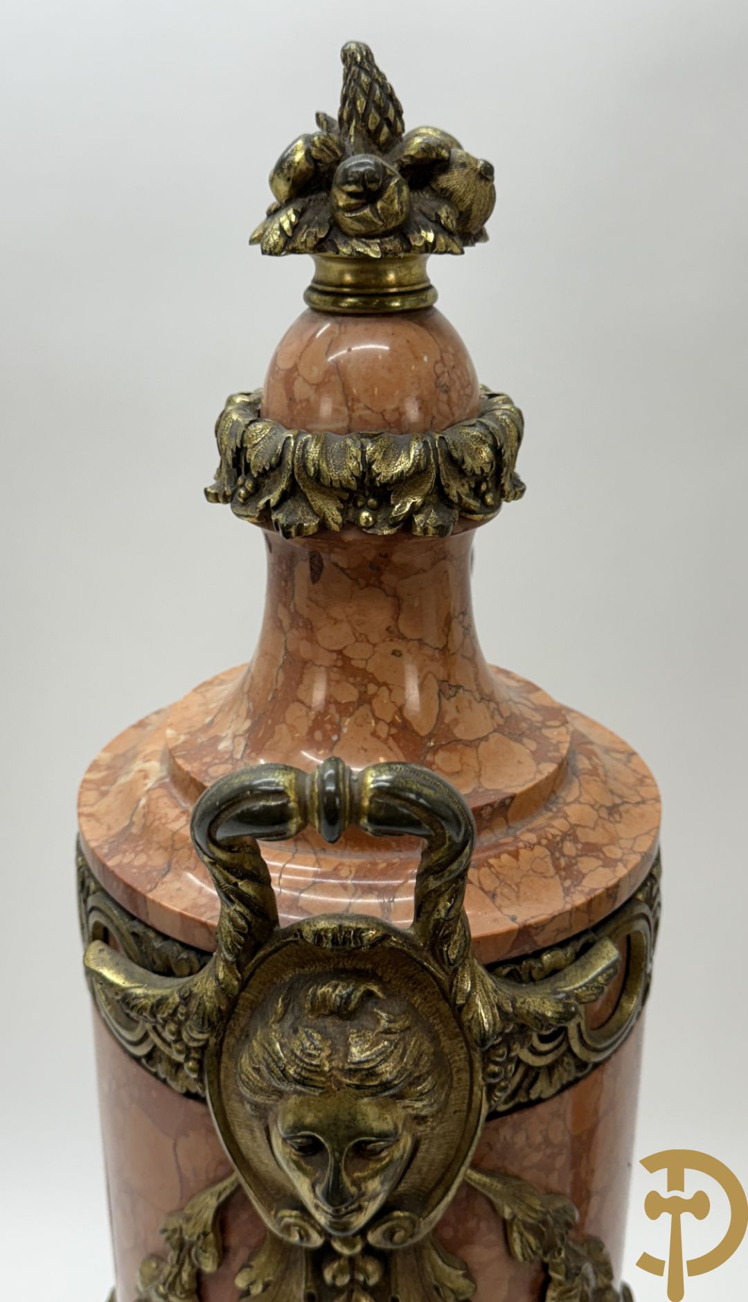 Paar oranje/rode marmeren cassolettes, zijdelings bezet met dameshoofden dragende een guirlande van bloemen - bovenaan met bloementroffee