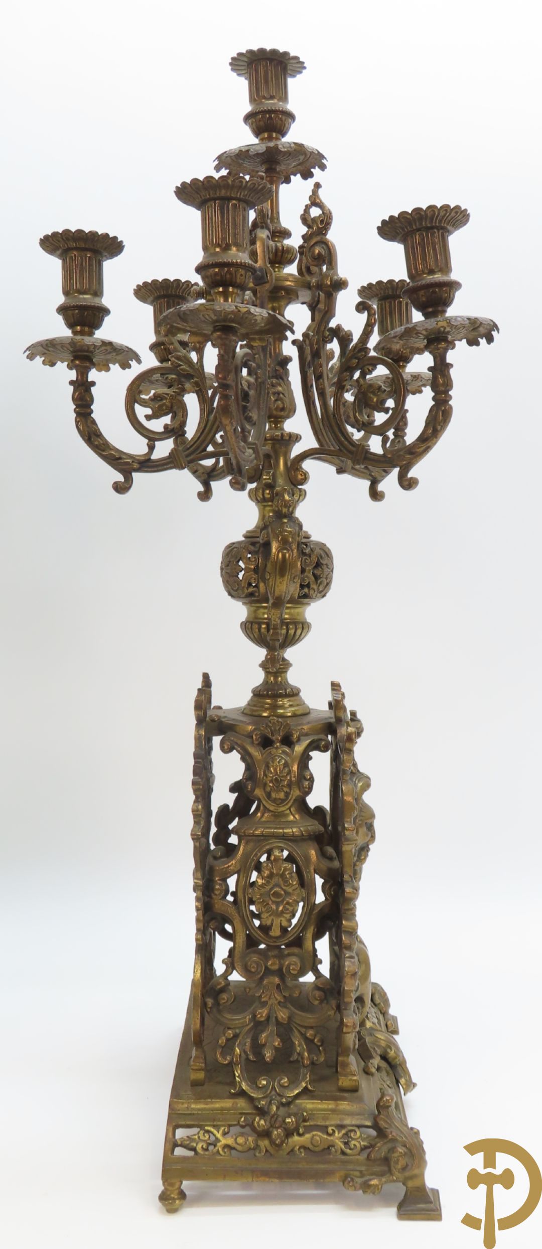 Driedelige bronzen garnituur bestaande uit middenstuk bezet met accanthusranken, drakenmotieven en leeuwenkoppen geflankeerd door paar kandelaars met hermenfiguren en accanthusranken