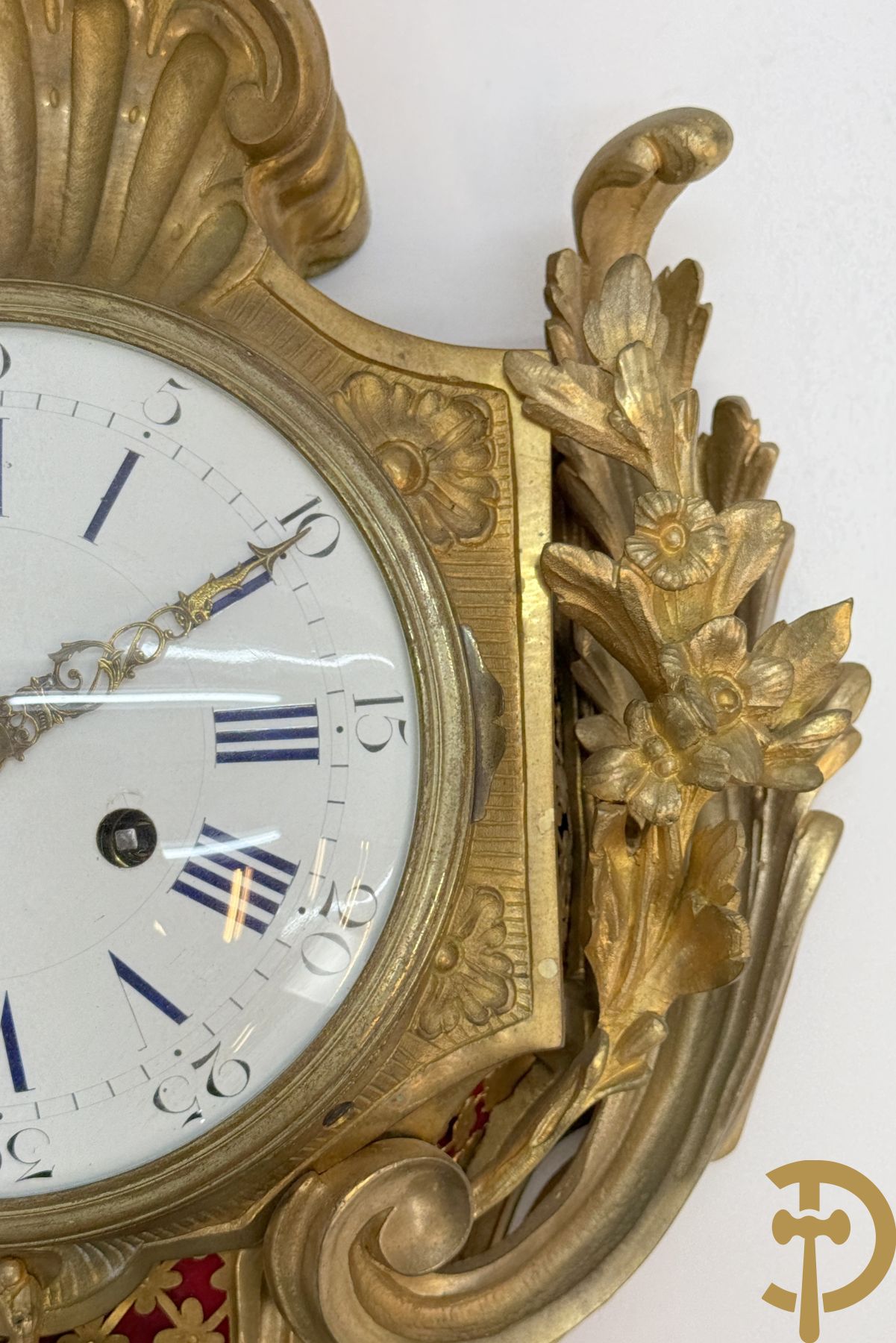 Bronzen muurkartel Louis XV stijl met bloemenmotieven en bovenaan bezet met faune met triangle, Molle Paris getekend binnenin op uurwerk