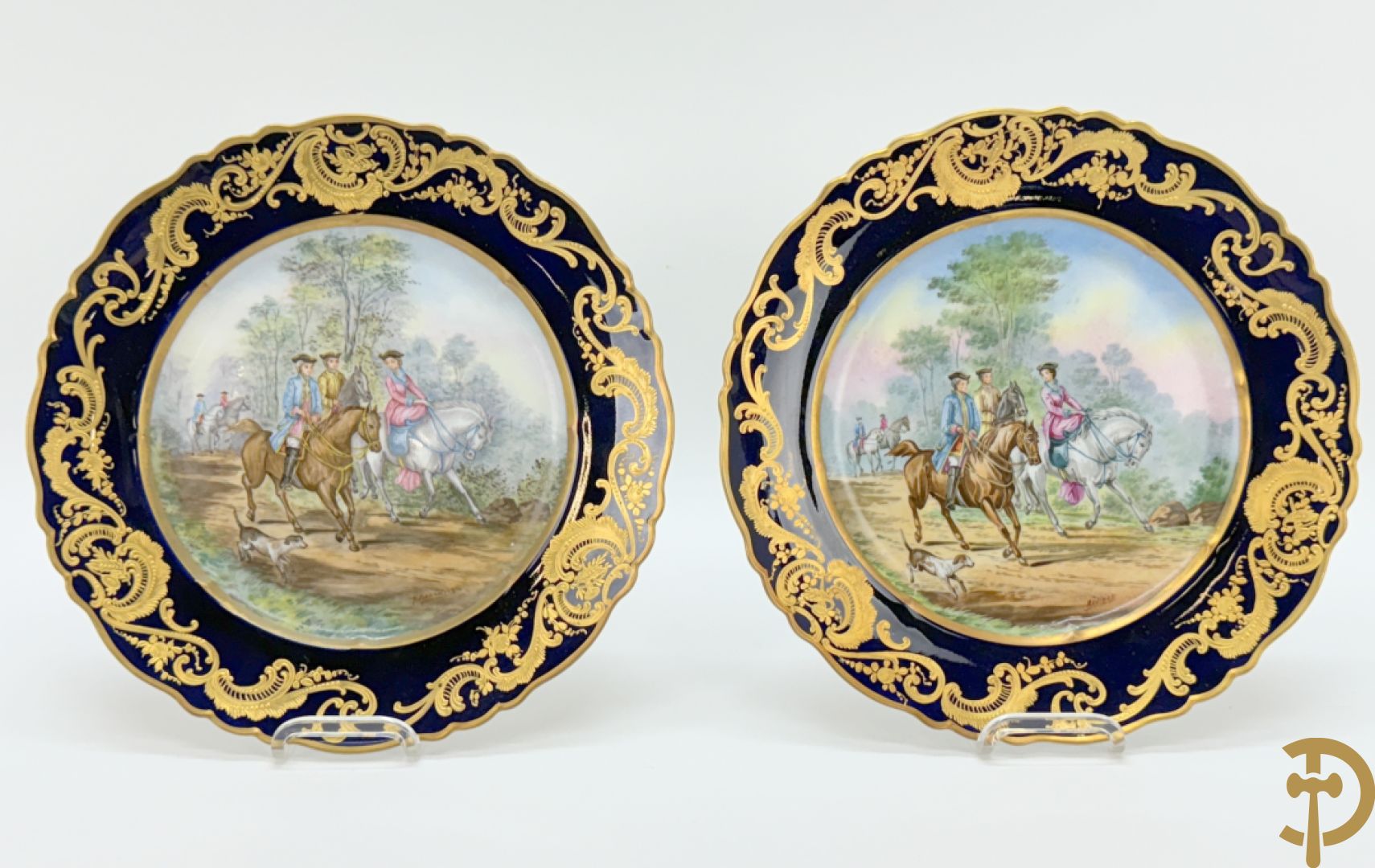 Paar porseleinen borden met ruitertafereel met vergulde omranding, getekend Rivière en Bourdier P., achteraan gemerkt met gekruiste pijlen